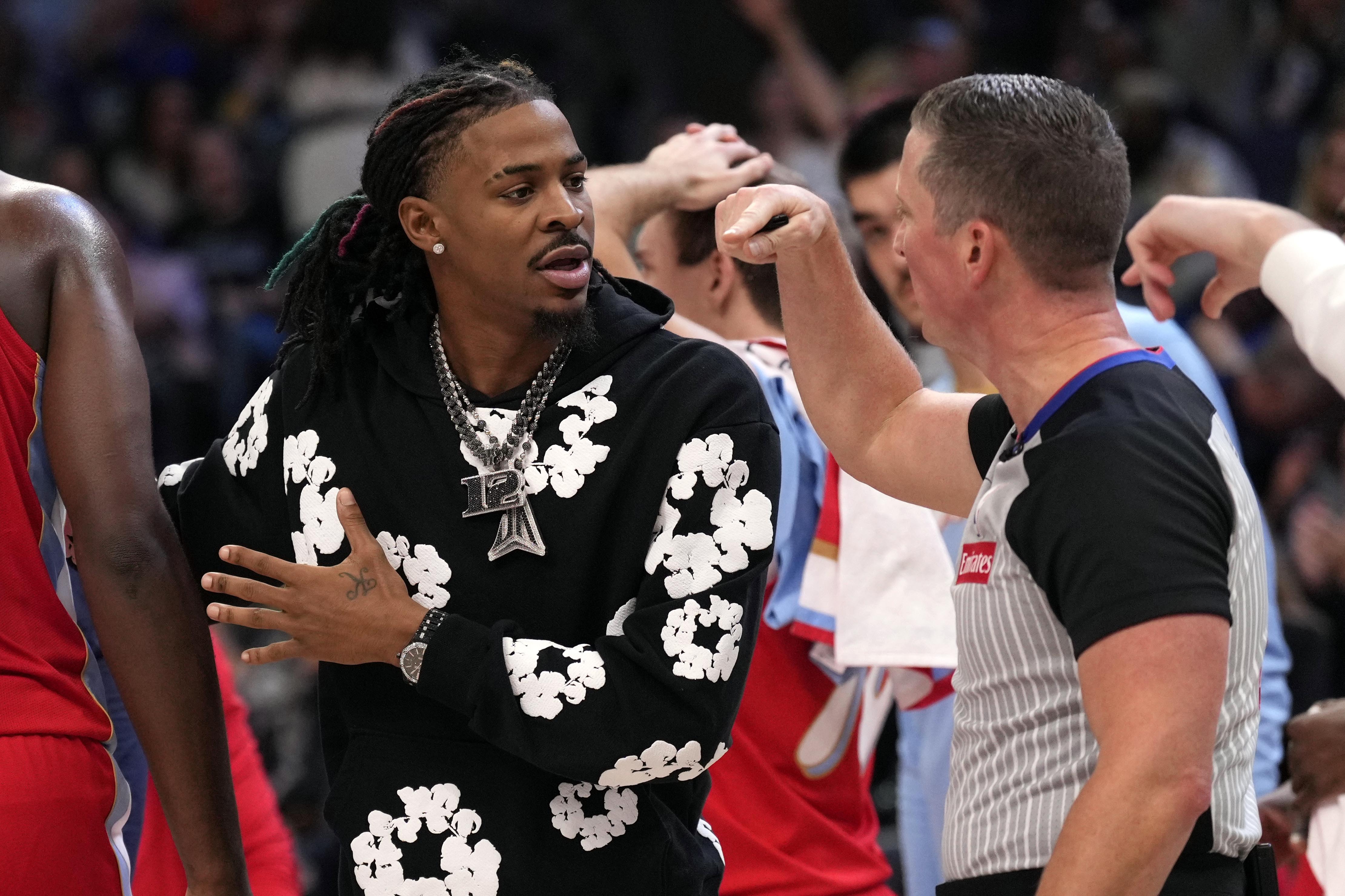 Injured Memphis Grizzlies guard Ja Morant argues with an official during a timeout in the first half of an NBA basketball game against the Denver Nuggets, Sunday, Nov. 17, 2024, in Memphis, Tenn.