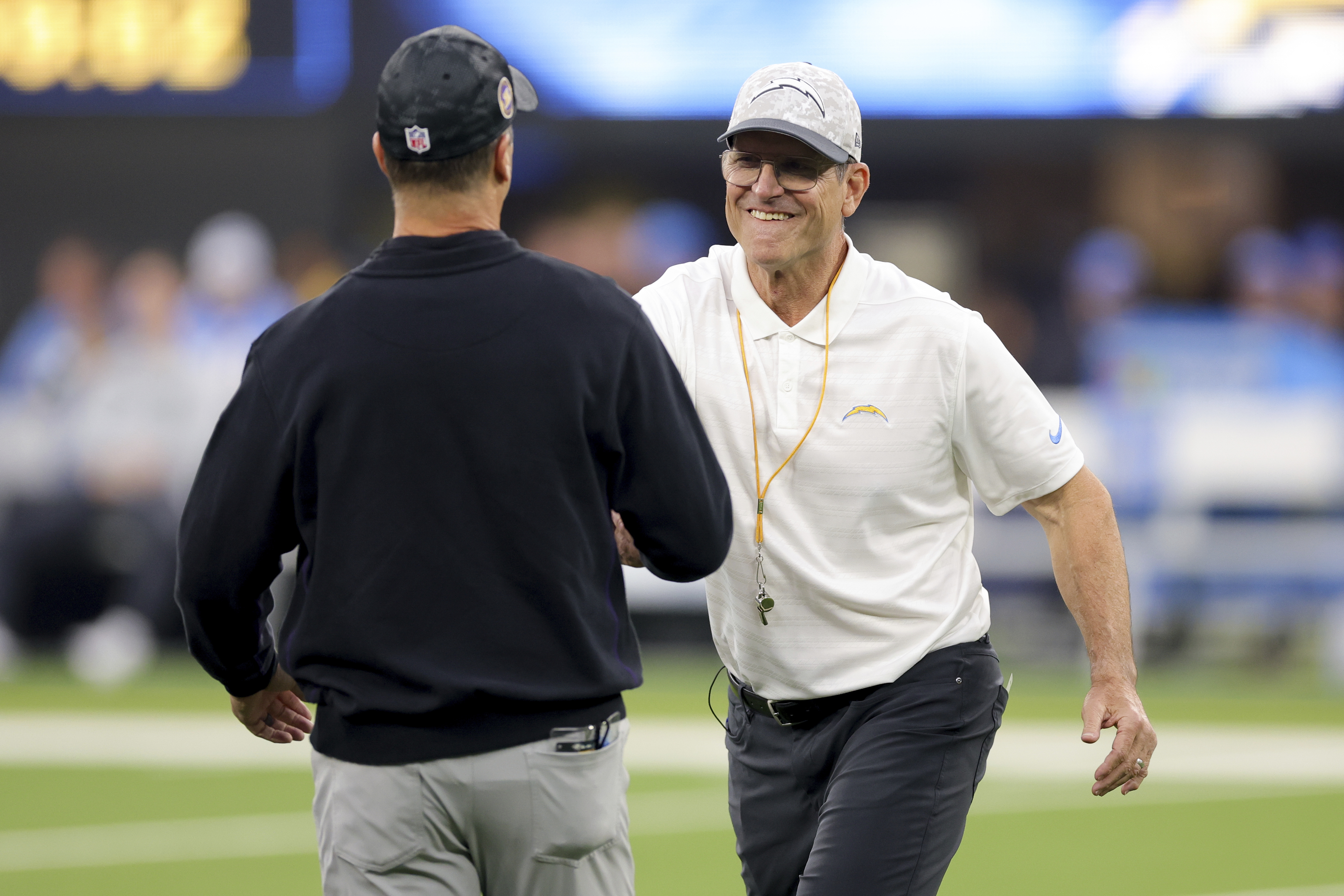 Los Angeles Chargers head coach Jim Harbaugh, right, shakes hands with his brother, Baltimore Ravens Head Coach John Harbaugh, before an NFL football game Monday, Nov. 25, 2024, in Inglewood, Calif.