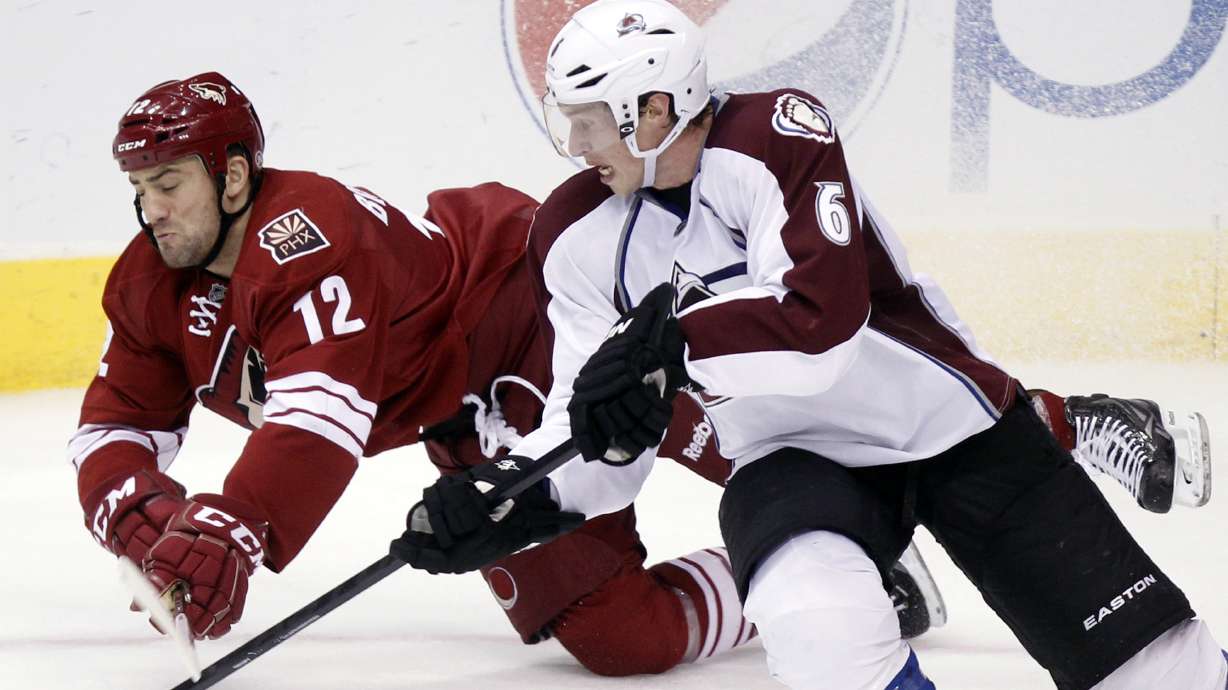 FILE - Phoenix Coyotes left winger Paul Bissonnette, left, and Colorado Avalanche defenseman Erik Johnson, right, compete for the puck in the third period of an NHL hockey game, April 6, 2013, in Glendale, Ariz.