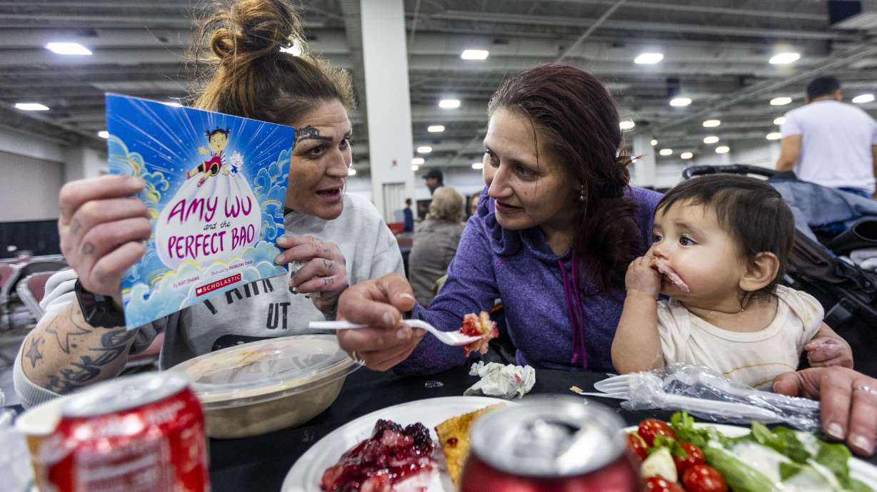 Treena Vigil, left, Danielle Cameron, center and her daughter Xochitl Gonzales, at the Larry H. Miller Company and the Miller family’s Thanksgiving Meal and Community Resource Event at the Salt Palace Convention Center in Salt Lake City on Monday.