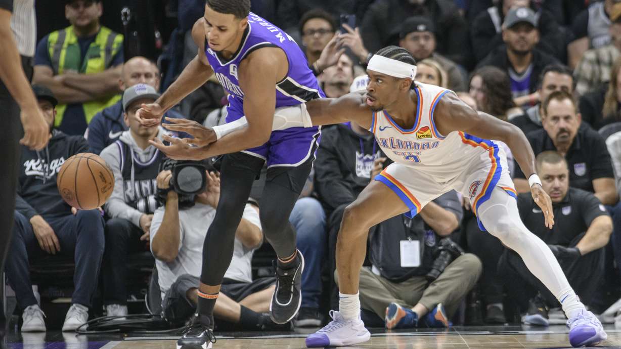 Oklahoma City Thunder guard Shai Gilgeous-Alexander, right, knocks the ball away from Sacramento Kings forward Keegan Murray, left, during the first half of an NBA basketball game in Sacramento, Calif., Monday, Nov. 25, 2024.