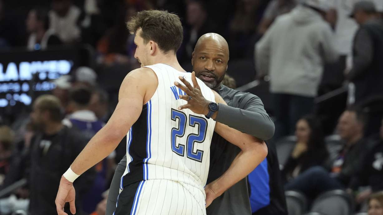 Orlando Magic forward Franz Wagner (22) celebrates with Magic head coach Jamahl Mosley, right, in the closing moments of the second half of an NBA basketball game against the Phoenix Suns, Monday, Nov. 18, 2024, in Phoenix.