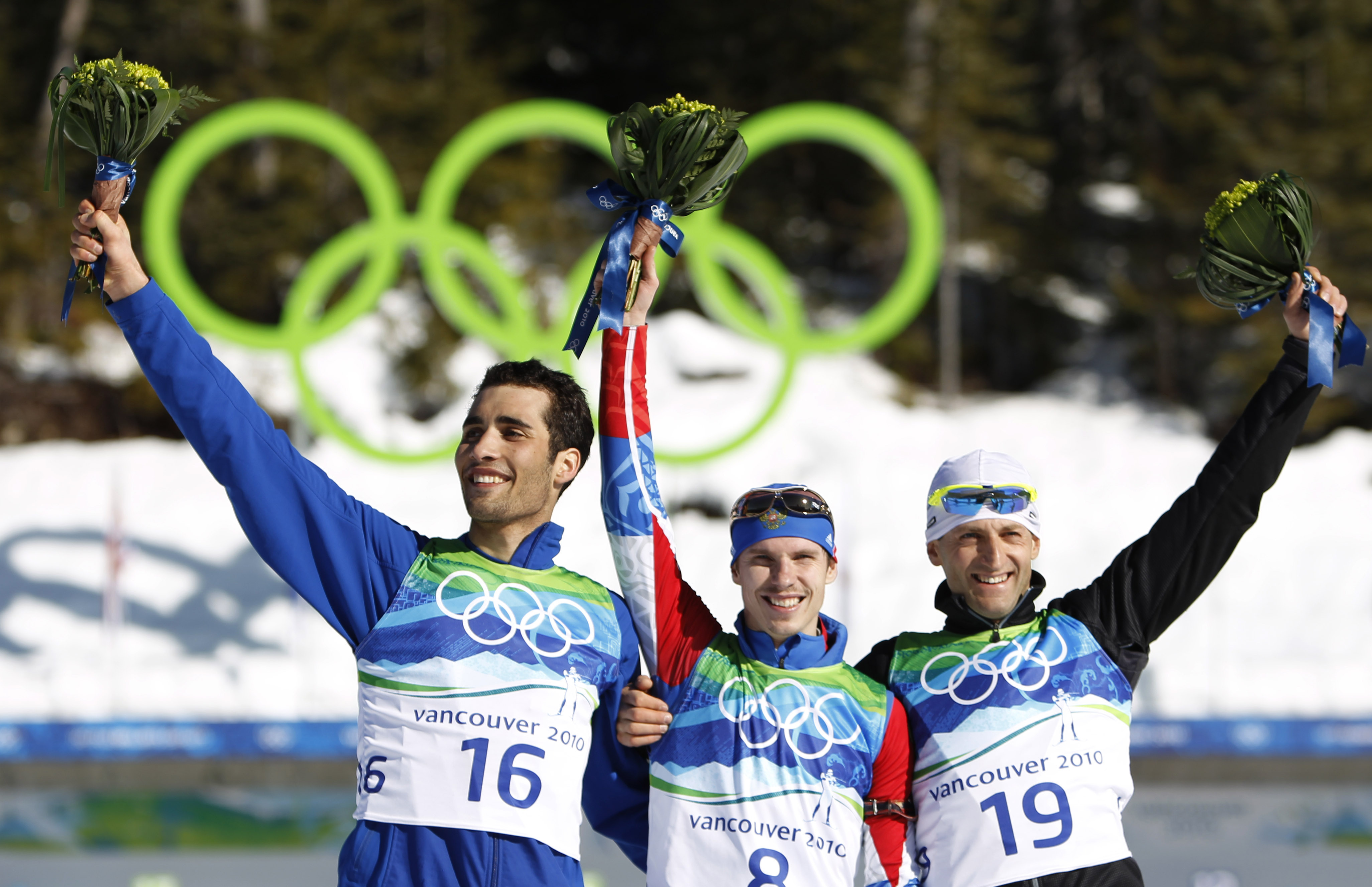 FILE - Gold medallist Russia's Evgeny Ustyugov, center, jubilates with silver medallist Martin Fourcade of France, left, and bronze medallist Slovakia's Pavol Hurajt during the flower ceremony after winning the men's 15 km biathlon mass start at the Vancouver 2010 Olympics in Whistler, British Columbia, Sunday, Feb. 21, 2010.