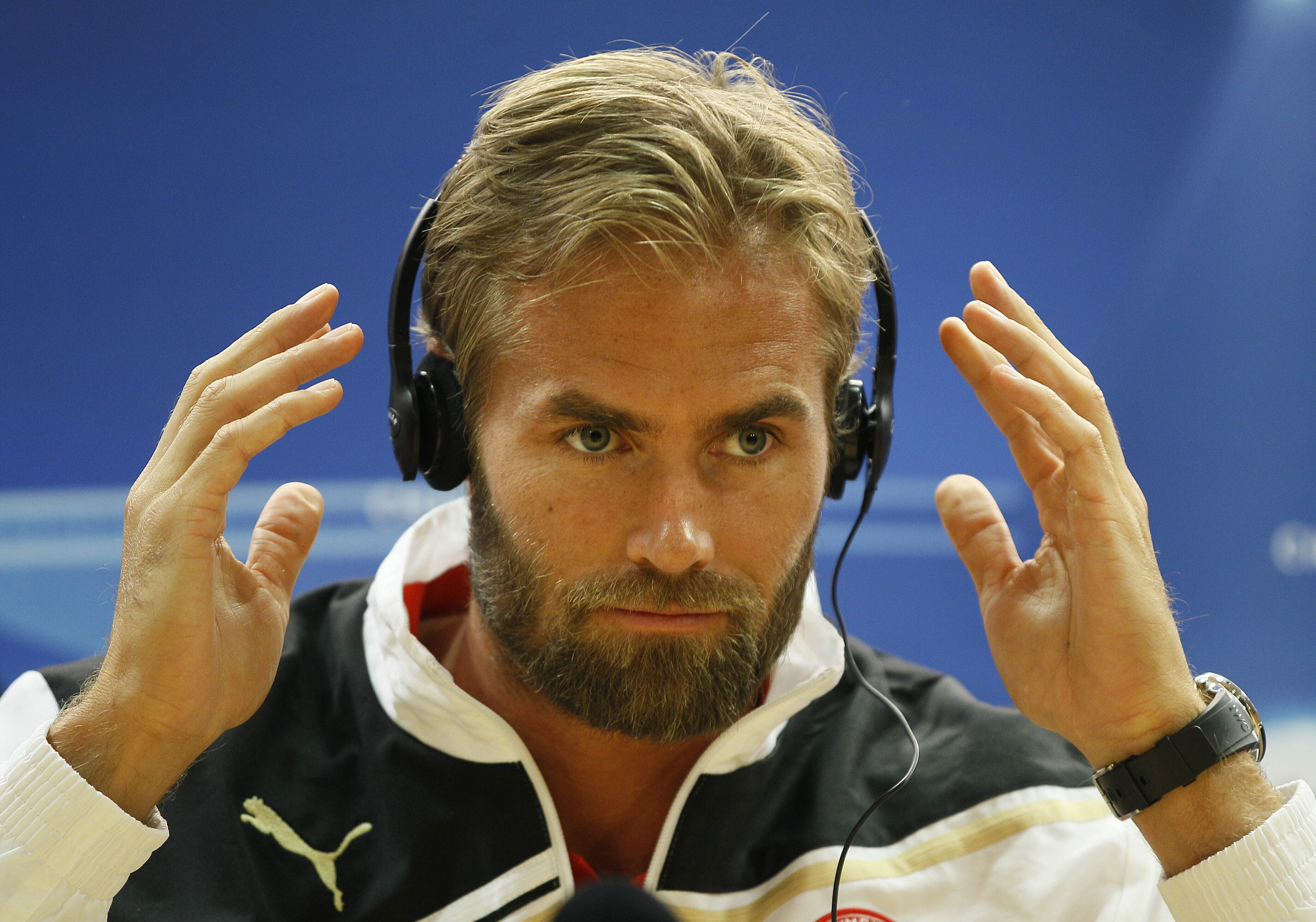 FILE - Olympiacos player Olof Mellberg holds translation headphones during a press conference at Arsenal's Emirates Stadium in London, Tuesday, Sept. 27, 2011. 