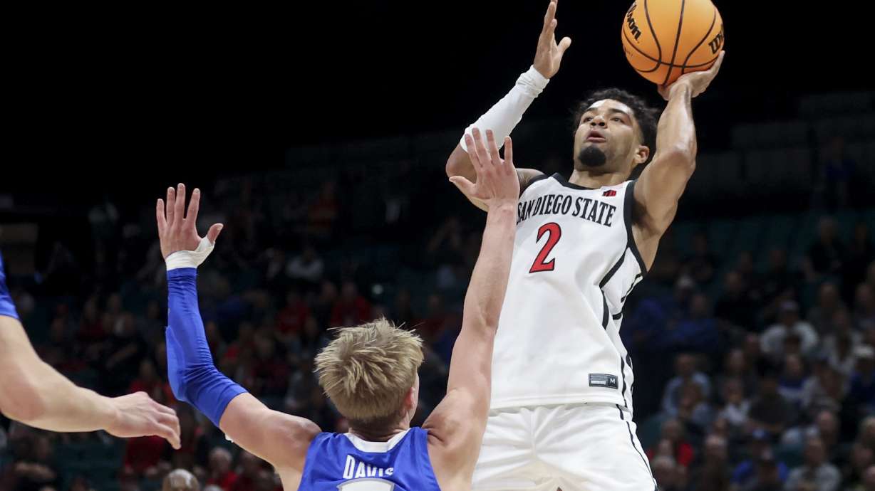 San Diego State guard Nick Boyd (2) shoots over Creighton guard Ty Davis (9) during the first half of an NCAA basketball game Tuesday, Nov. 26, 2024, in Las Vegas.