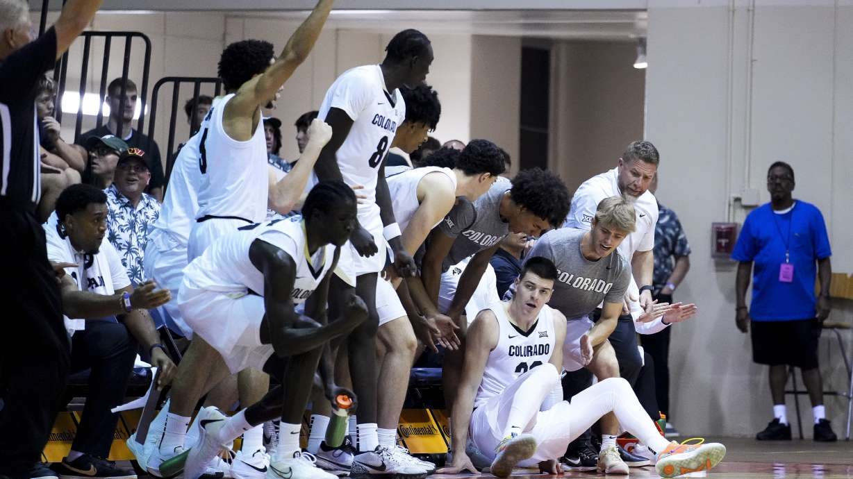 Colorado forward Andrej Jakimovski sits up while being greeted by the bench after falling while making a basket against UConn during the second half of an NCAA college basketball game at the Maui Invitational Tuesday, Nov. 26, 2024, in Lahaina, Hawaii. Colorado won 73-72.