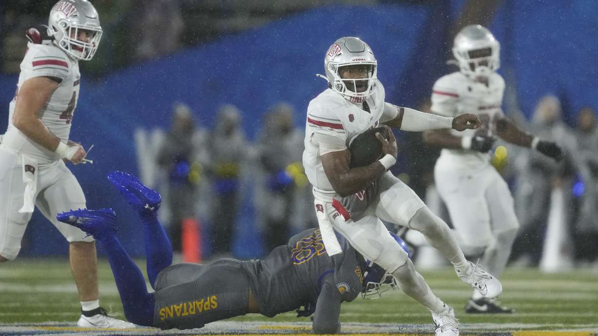 UNLV quarterback Hajj-Malik Williams, right, runs past San Jose State linebacker Ethan Powell (26) during the second half of an NCAA college football game Friday, Nov. 22, 2024, in San Jose, Calif.
