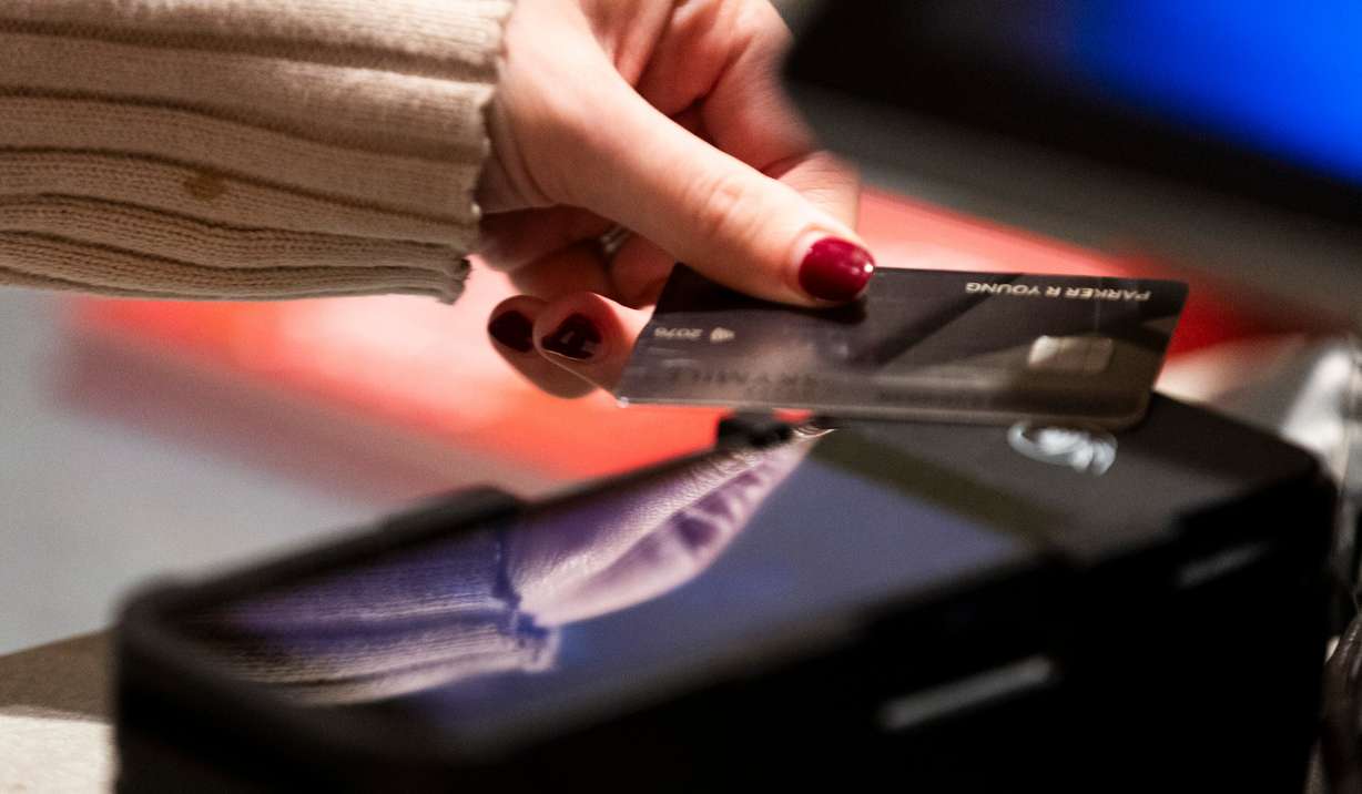 A shopper pays at Anthropologie in City Creek Center in Salt Lake City on Friday, Nov. 22.