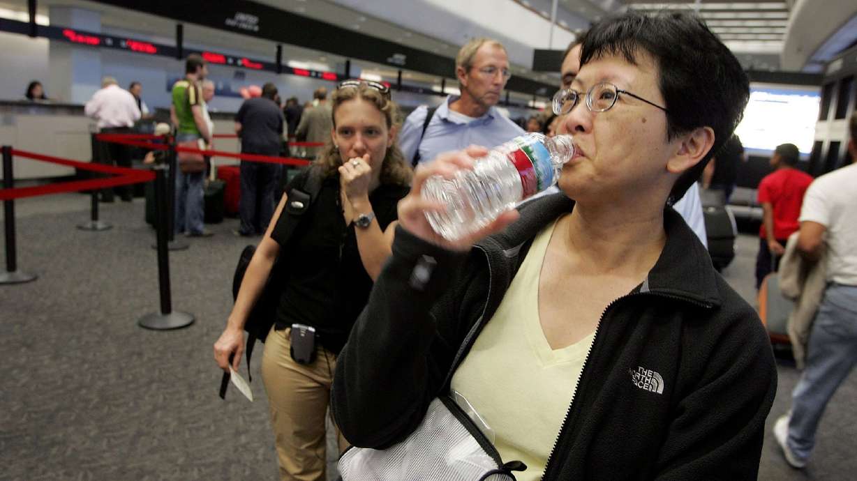 A passenger takes a sip of water before throwing away the bottle at a security checkpoint at San Francisco International Airport. There is a way to get a bottle of water through airport security in the U.S.
