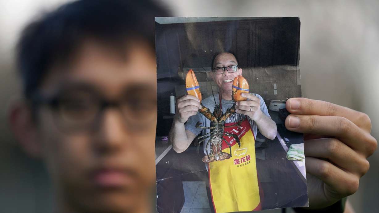 Harrison Li holds a photo of his father, Kai Li, as he poses for a photo, Jan. 23, in Palo Alto, Calif. Three American citizens imprisoned for years by China, including Li, have been released.