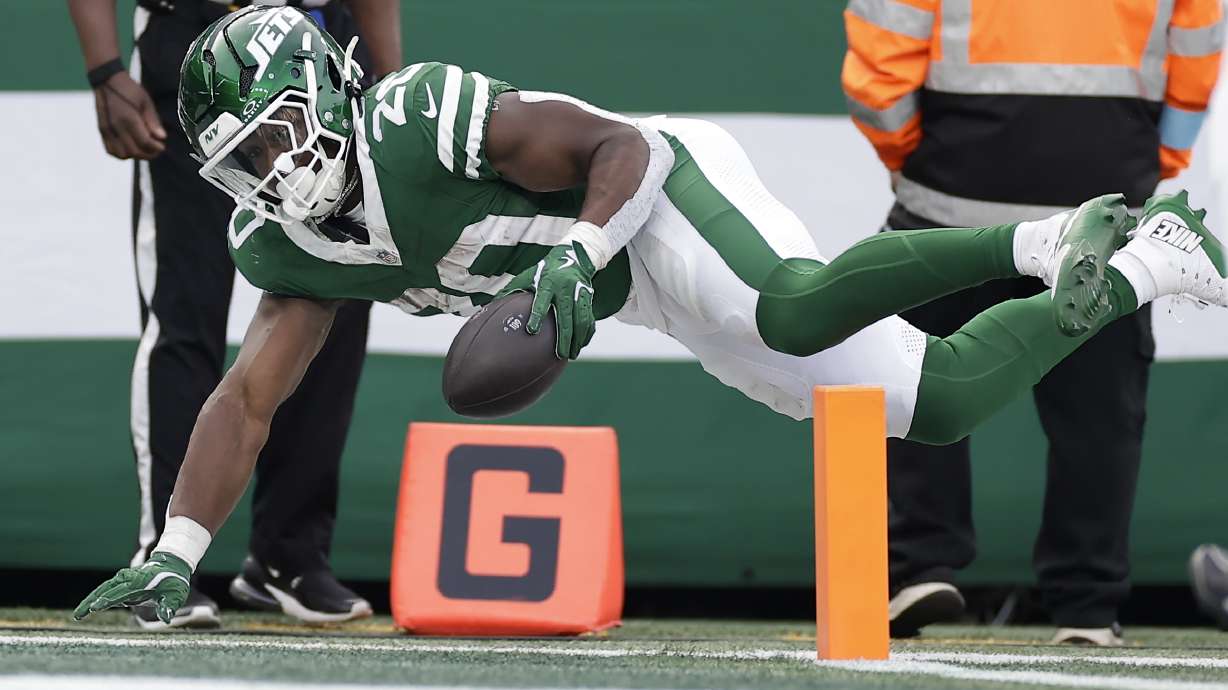 New York Jets running back Breece Hall (20) reaches the ball across the goal line for a touchdown against the Indianapolis Colts during the third quarter of an NFL football game, Sunday, Nov. 17, 2024, in East Rutherford, N.J.