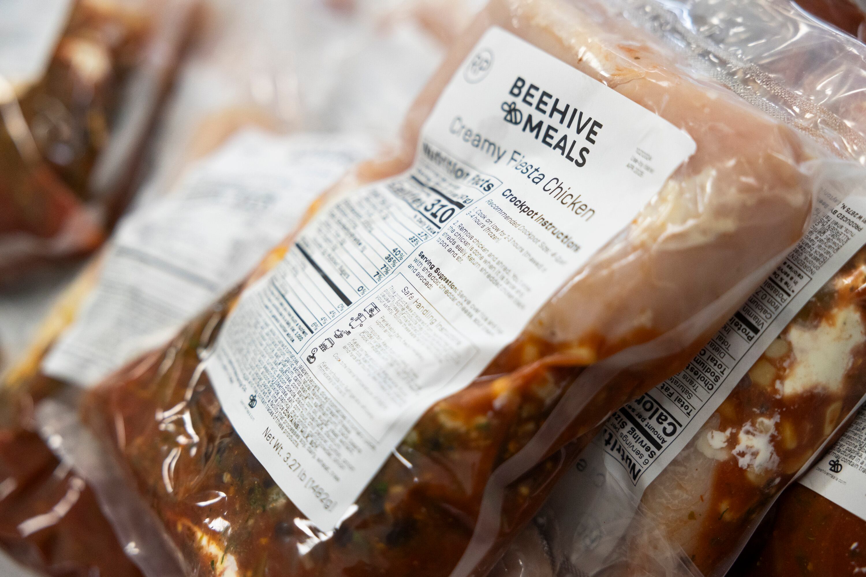 Packages of Beehive Meals’ Creamy Fiesta Chicken sit in a pile after being prepared by workers at the Beehive Meals kitchen in Layton on Monday, Oct. 21.