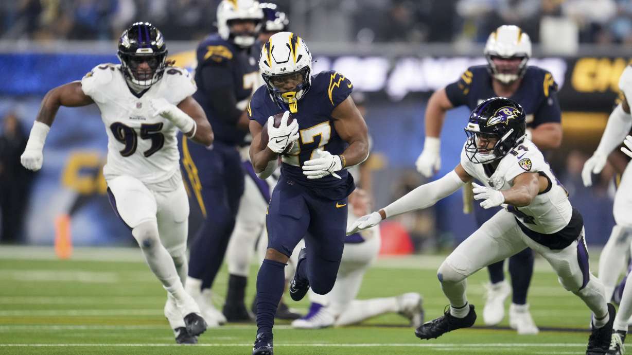 Los Angeles Chargers running back J.K. Dobbins (27) runs past Baltimore Ravens safety Kyle Hamilton (14) during the first half of an NFL football game Monday, Nov. 25, 2024, in Inglewood, Calif.