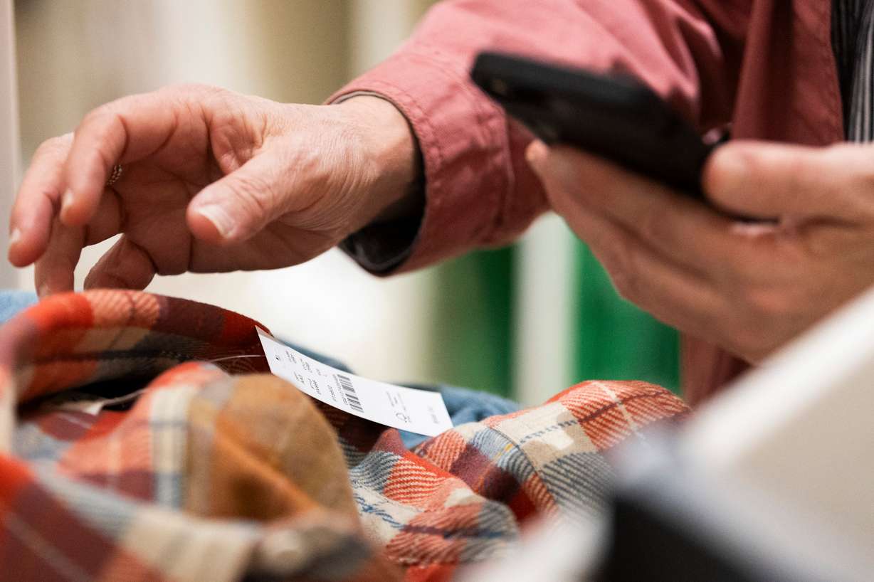Cashier Teri Toro scans tags while checking customers out at J.Crew in City Creek Center in Salt Lake City on Friday.