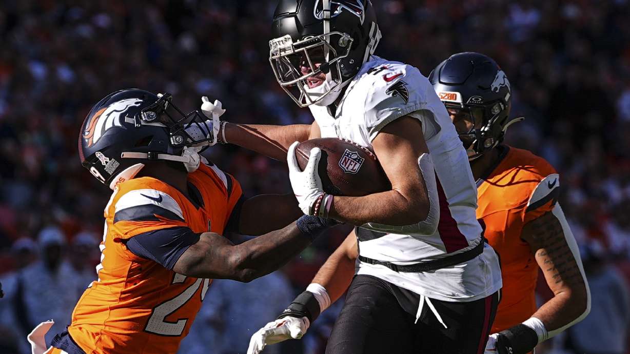 Atlanta Falcons wide receiver Drake London (5) makes the catch against Denver Broncos cornerback Ja'Quan McMillian (29) during the first half of an NFL football game, Sunday, Nov. 17, 2024, in Denver.