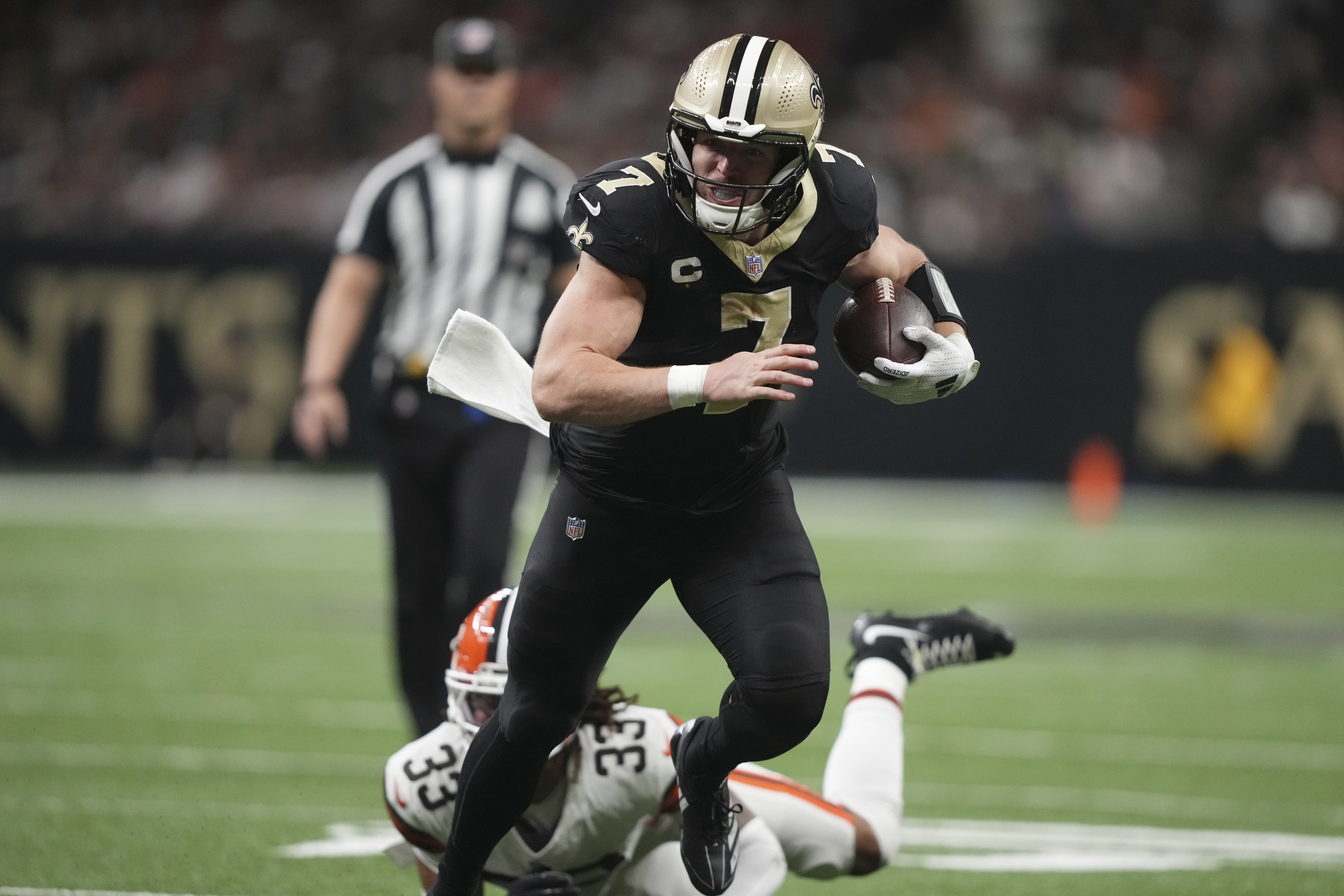 New Orleans Saints tight end Taysom Hill (7) carries in for a touchdown pst Cleveland Browns safety Ronnie Hickman (33) in the second half of an NFL football game in New Orleans, Sunday, Nov. 17, 2024. 