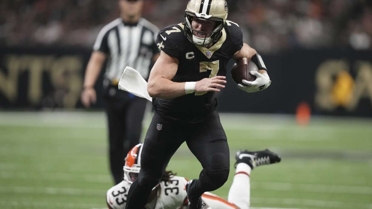 New Orleans Saints tight end Taysom Hill (7) carries in for a touchdown pst Cleveland Browns safety Ronnie Hickman (33) in the second half of an NFL football game in New Orleans, Sunday, Nov. 17, 2024.