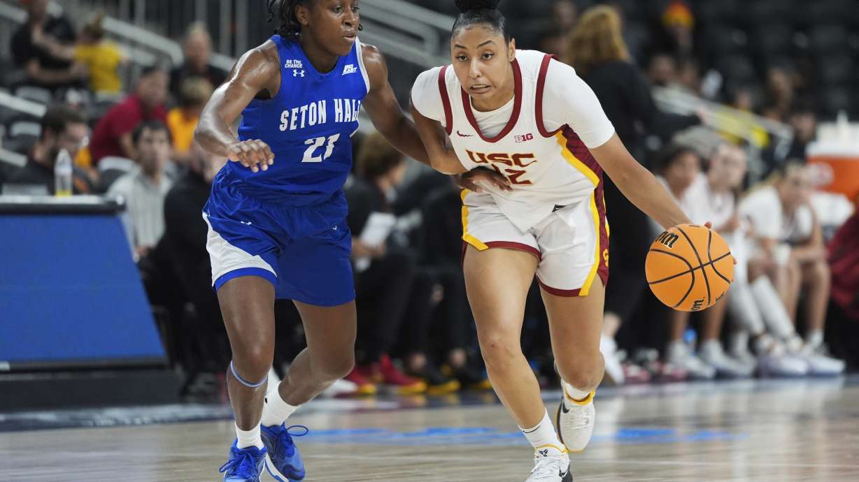 Southern California guard JuJu Watkins (12) drives past Seton Hall guard Shailyn Pinkney (21) during the first half of an NCAA women's college basketball game in Palm Desert, Calif., Wednesday, Nov. 27, 2024.