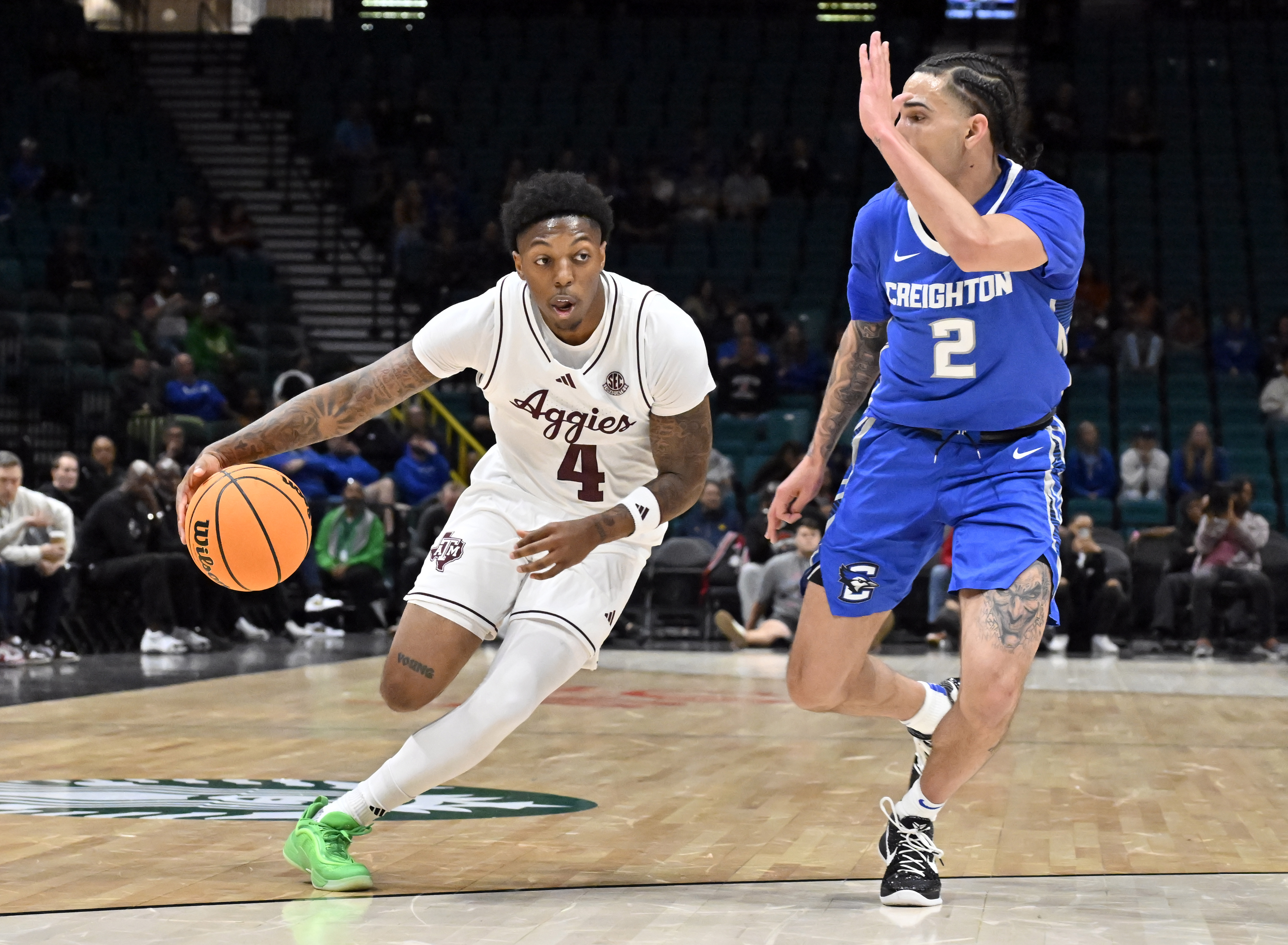 Texas A&M guard Wade Taylor IV (4) drives the ball against Creighton guard Pop Isaacs (2) during the first half of an NCAA college basketball game Wednesday, Nov. 27, 2024, in Las Vegas.
