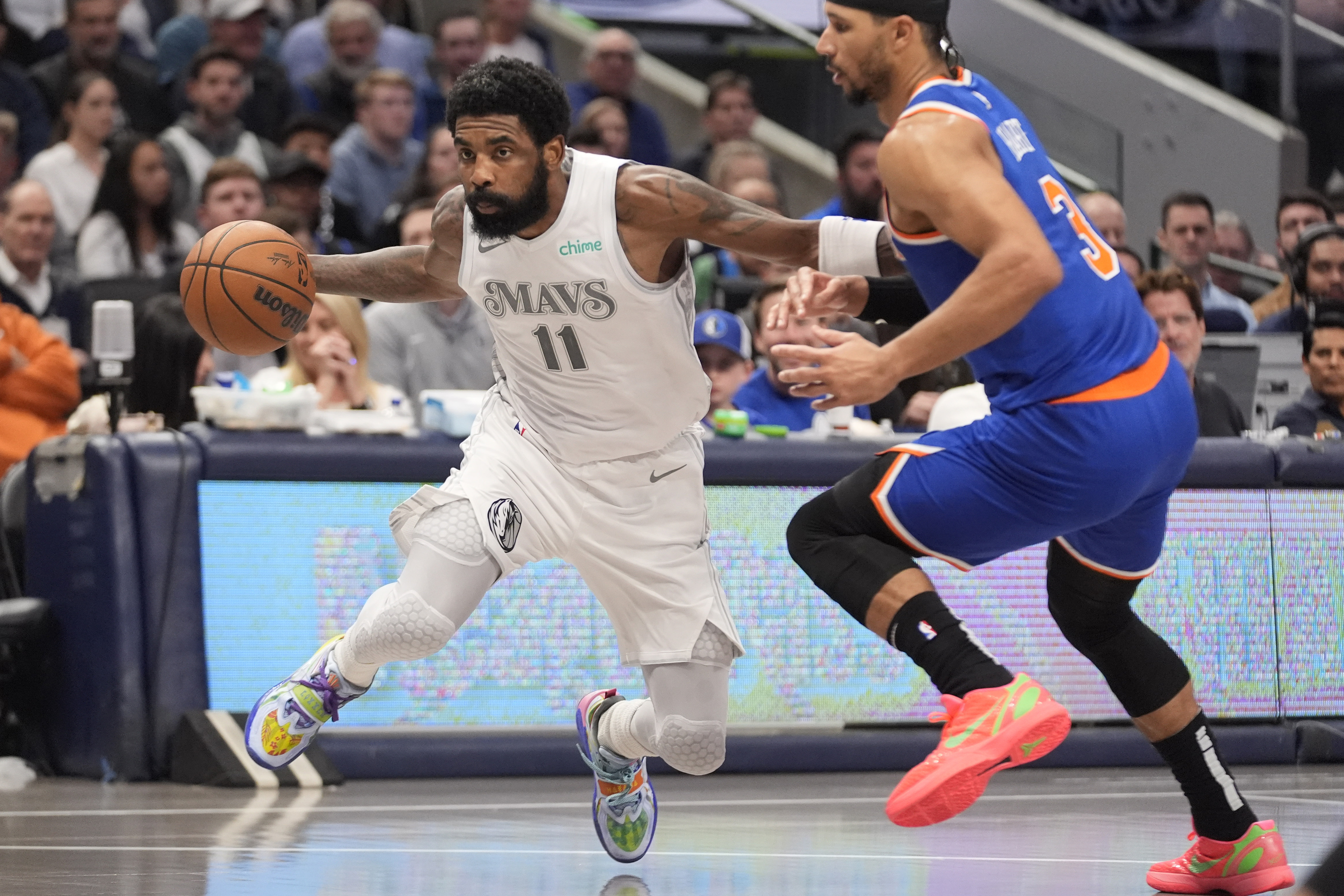 Dallas Mavericks guard Kyrie Irving (11) drives past New York Knicks guard Josh Hart (3) during the first period of an NBA basketball game Wednesday, Nov. 27, 2024, in Dallas.