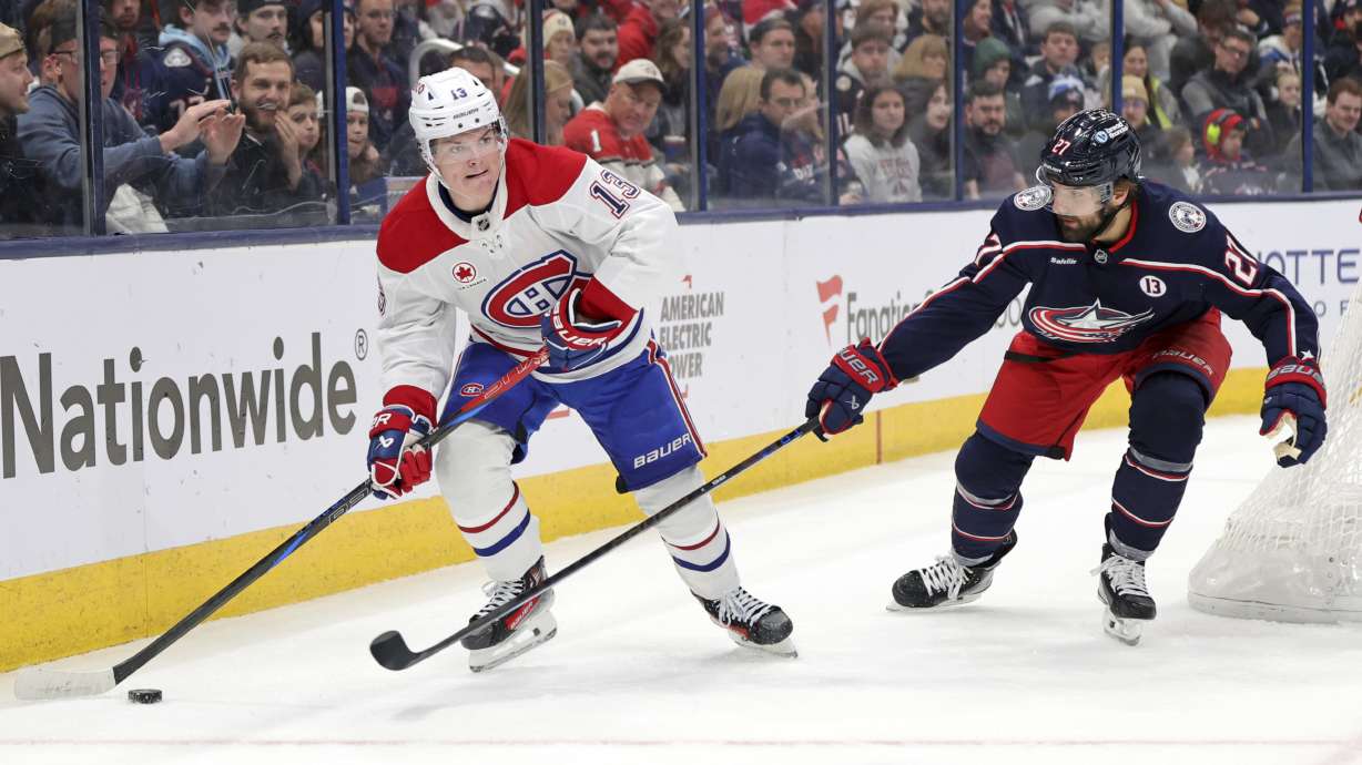 Montreal Canadiens forward Cole Caufield, left, controls the puck in front of Columbus Blue Jackets defenseman Zachary Aston-Reese during the first period of an NHL hockey game in Columbus, Ohio, Wednesday, Nov. 27, 2024.