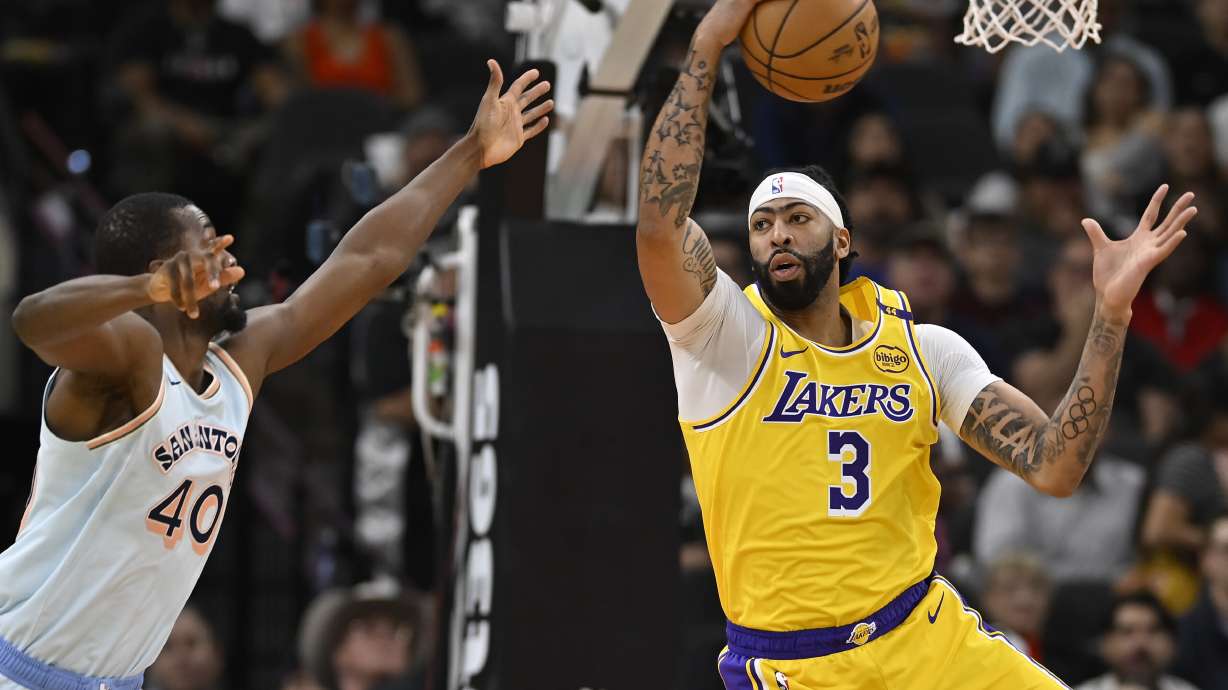 Los Angeles Lakers' Anthony Davis (3) grabs the rebound ahead of San Antonio Spurs' Harrison Barnes during the first half of an NBA basketball game, Wednesday, Nov. 27, 2024, in San Antonio.
