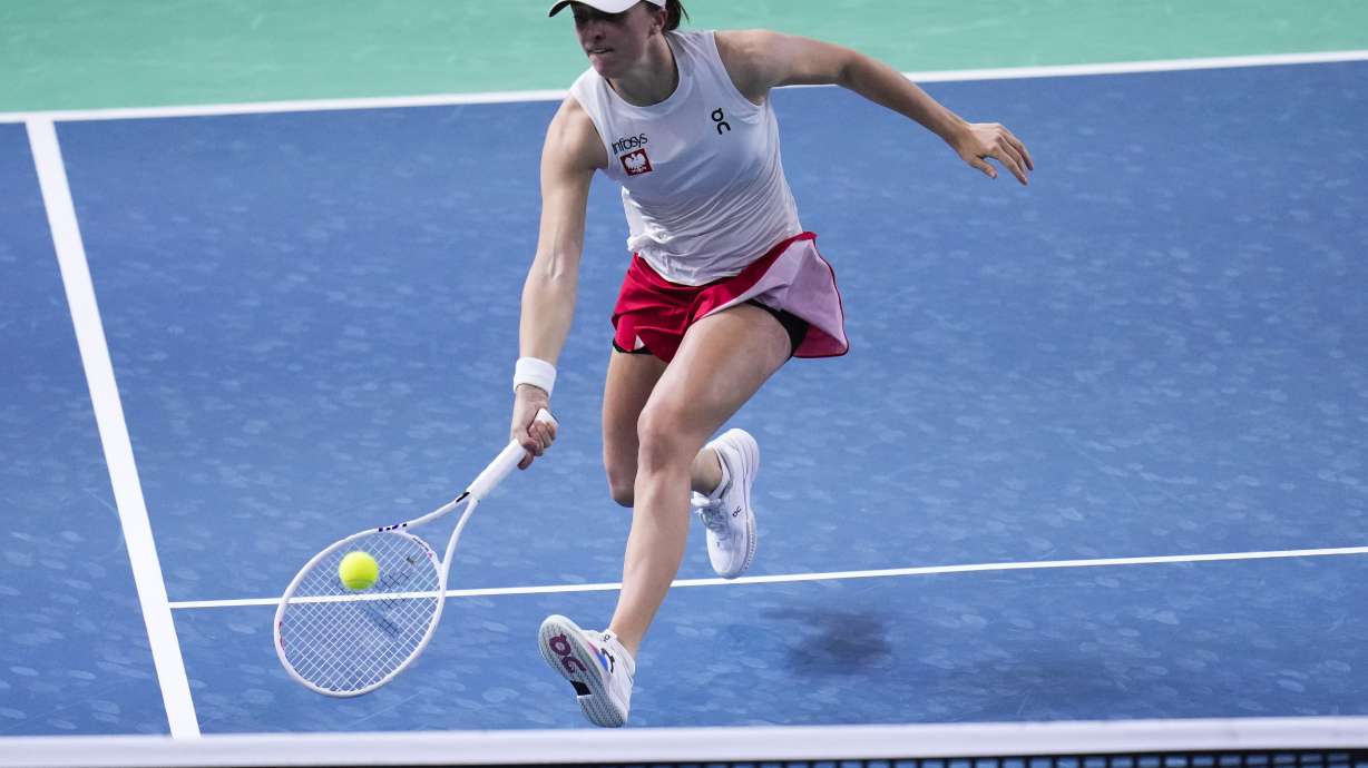 Poland's Iga Swiatek returns the ball against Italy's Jasmine Paolini during the Billie Jean King Cup semi-final tennis match at Martin Carpena Sports Hall in Malaga, southern Spain, on Monday, Nov. 18, 2024.