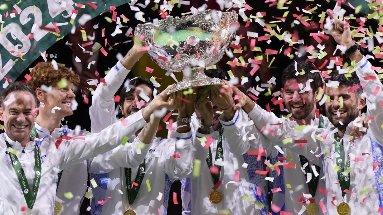 Italian tennis team members hold the Davis Cup trophy after the final between Netherlands and Italy at the Martin Carpena Sports Hall in Malaga, southern Spain, as Italy wins its second consecutive Davis Cup title, Sunday, Nov. 24, 2024.