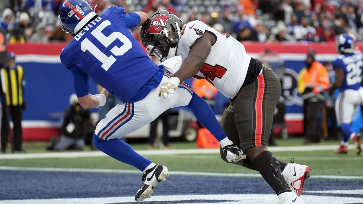 Tampa Bay Buccaneers defensive tackle Calijah Kancey (94) hits New York Giants quarterback Tommy DeVito (15) after a pass during the second half of an NFL football game Sunday, Nov. 24, 2024, in East Rutherford, N.J.