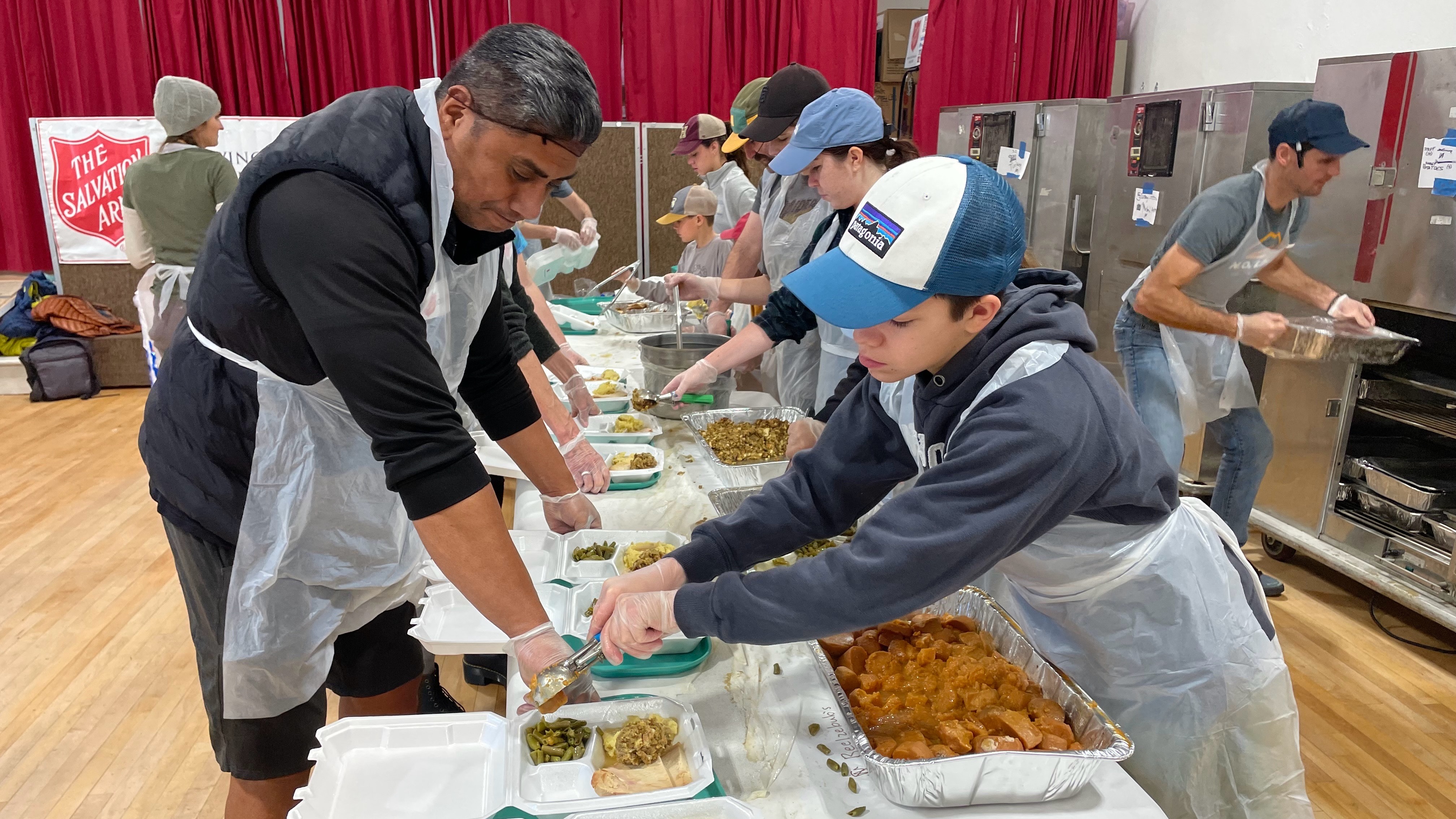 Volunteers prepare food to be delivered to homebound seniors at the Salvation Army in Salt Lake City on Thursday.