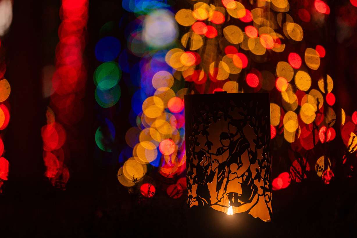 A nativity scene is illuminated by a candle in front of some Christmas lights at the Conference Center in Salt Lake City on Nov. 26, 2023.