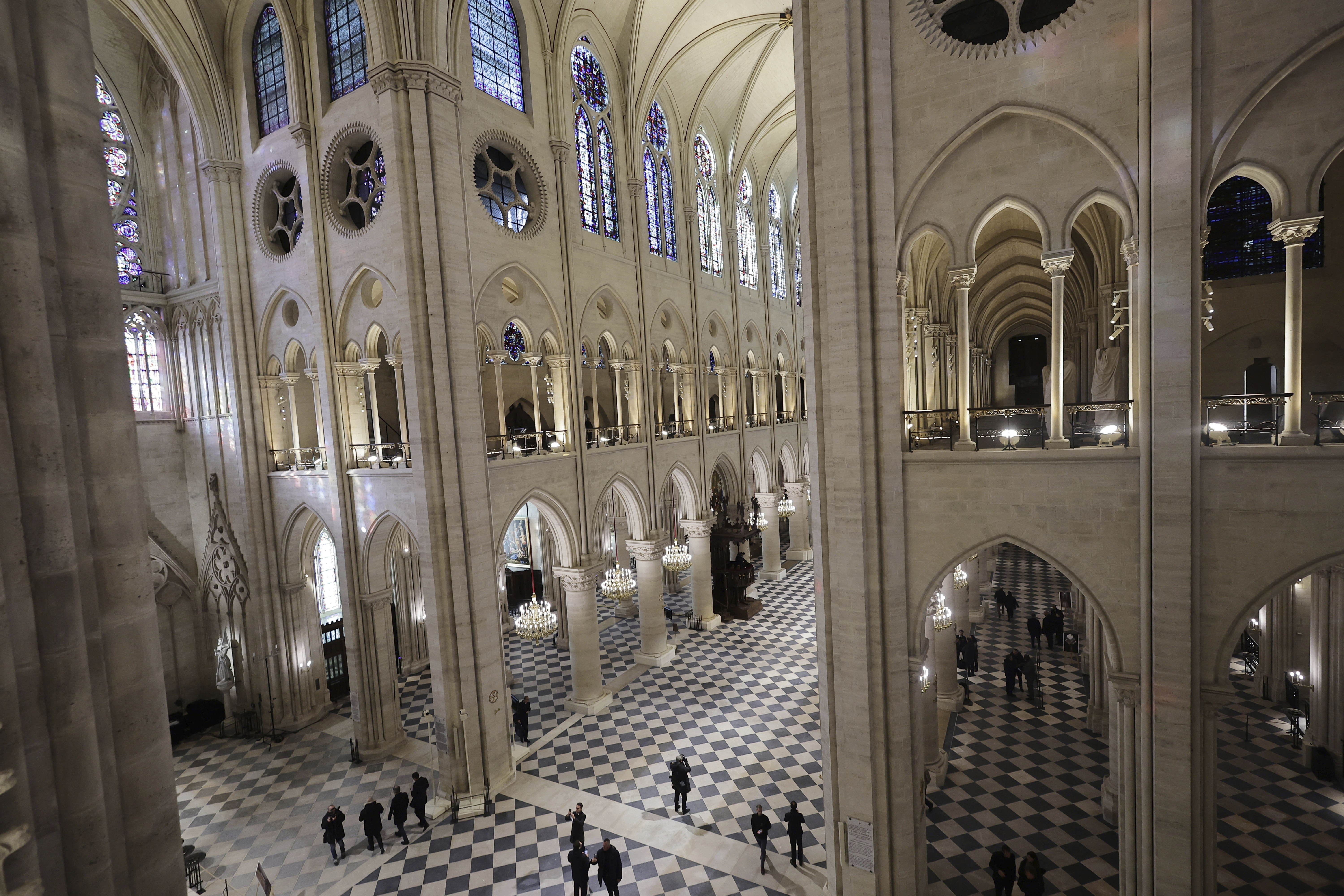 People stroll in Notre-Dame de Paris Cathedral while French President Emmanuel Macron visits the restored interiors the monument, Friday in Paris.