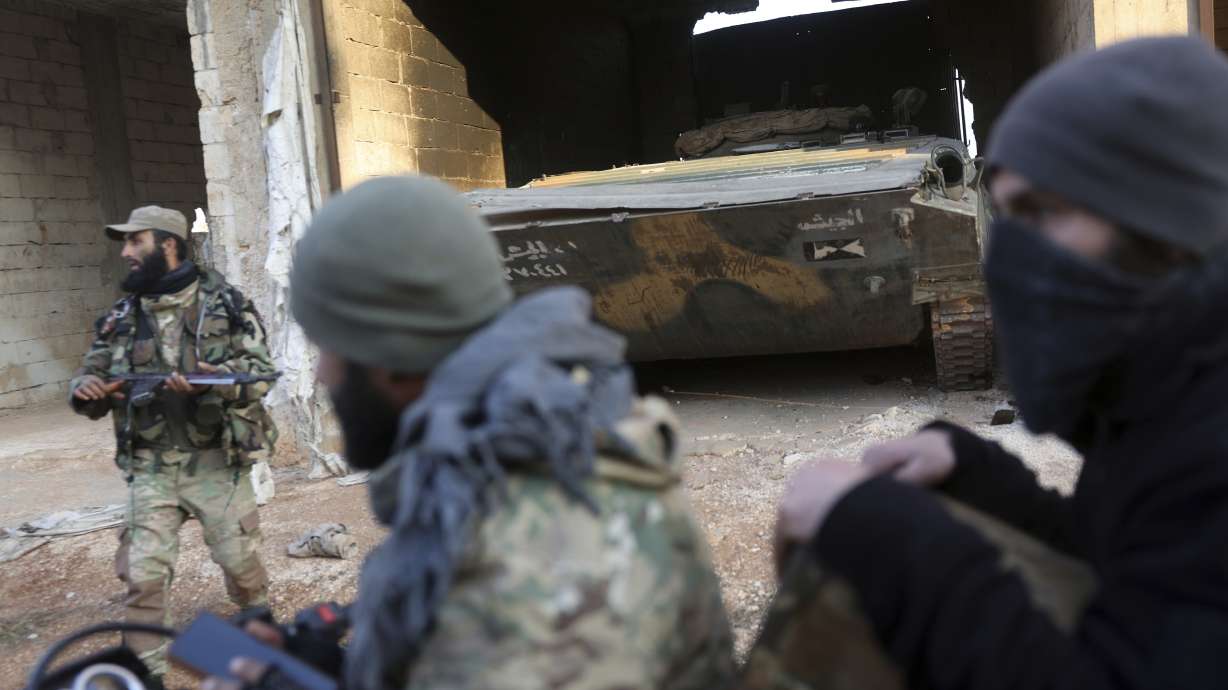 Syrian opposition fighters ride in front of a tank they allegedly captured from Syrian Government troops in Talhiya, Idlib countryside, Syria, Friday.