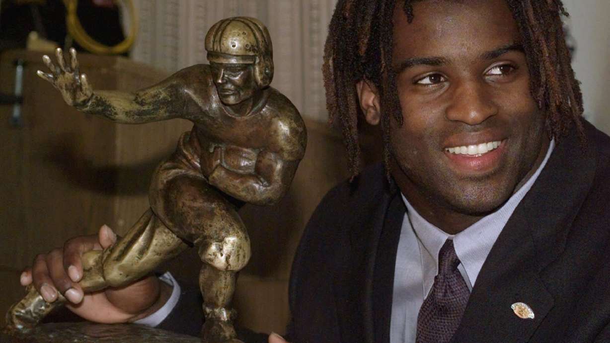 FILE - Texas NCAA college football tailback Ricky Williams poses with the Heisman Trophy at the Downtown Athletic Club in New York, Dec. 12, 1998.