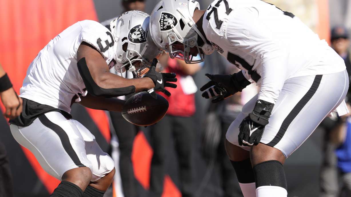 Las Vegas Raiders running back Zamir White, left, celebrates after scoring a touchdown with offensive tackle Thayer Munford Jr. (77) during the first half of an NFL football game against the Cincinnati Bengals in Cincinnati, Sunday, Nov. 3, 2024.