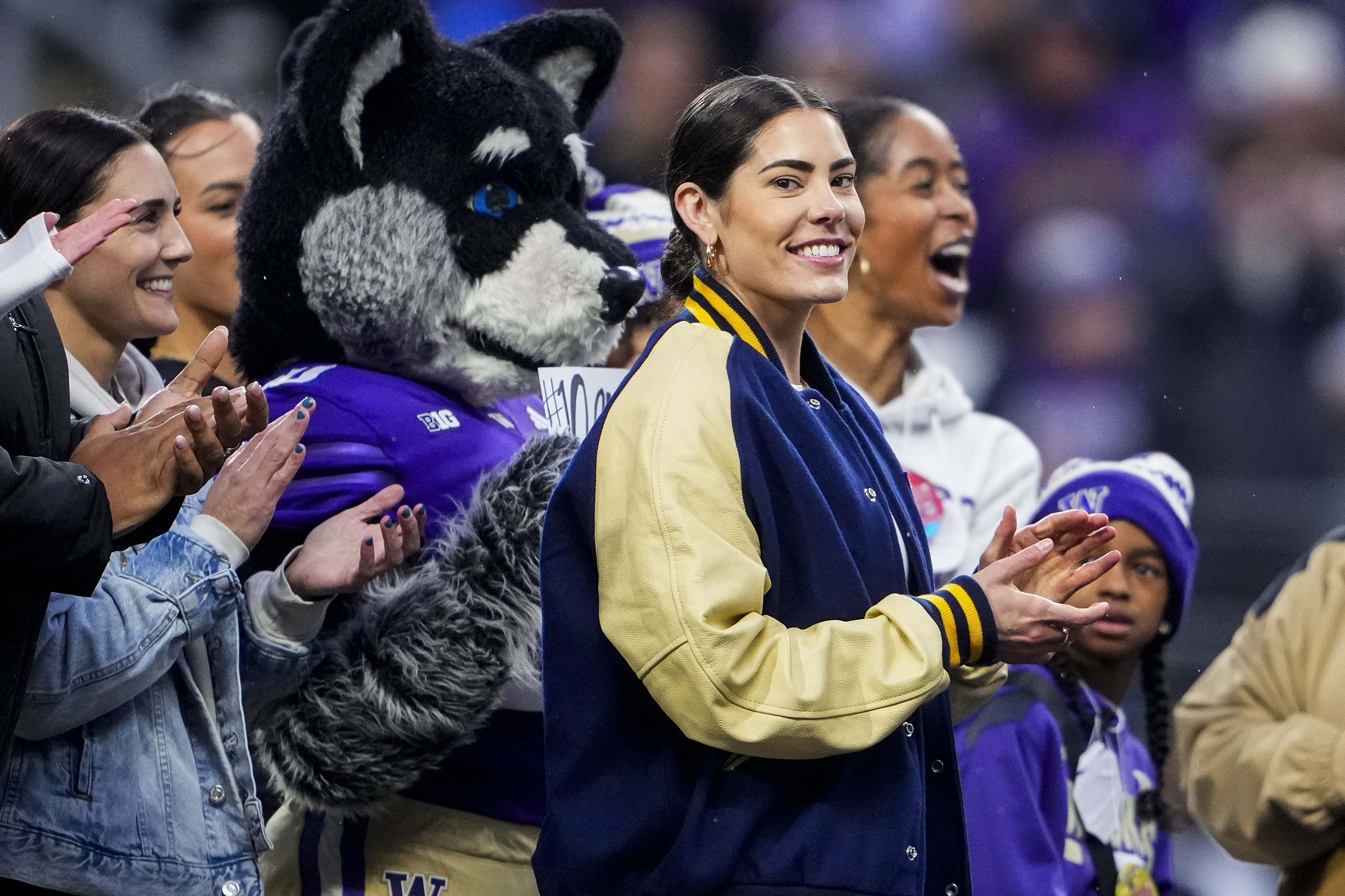Las Vegas Aces guard and former Washington player Kelsey Plum, front right, is recognized on the field during a timeout during the first half of an NCAA college football game between Washington and Southern California, Saturday, Nov. 2, 2024, in Seattle.