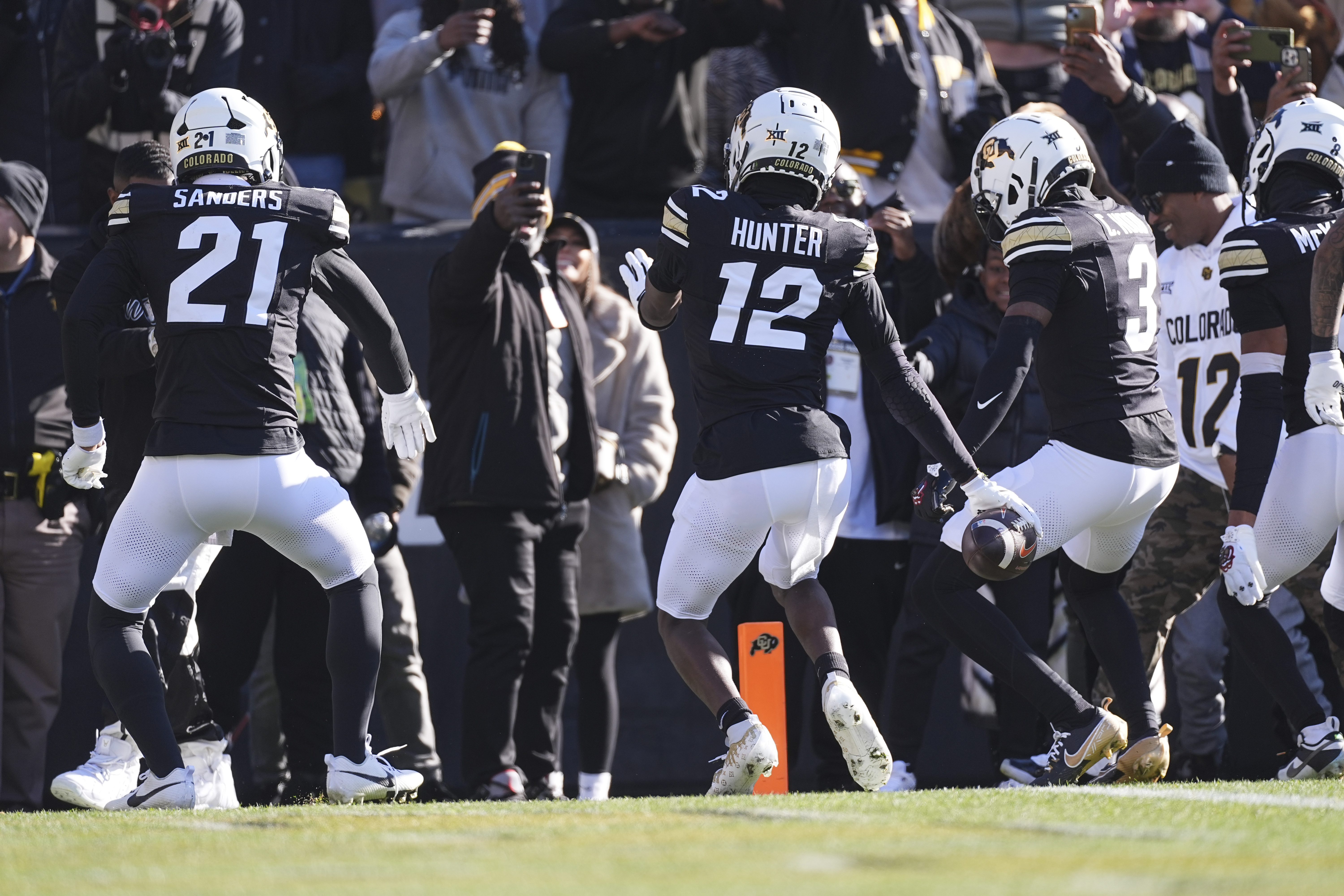Colorado defensive back Travis Hunter, center, dances after intercepting a pass with safety Shilo Sanders, left, and cornerback Colton Hood in the first half of an NCAA college football game against Oklahoma State Friday, Nov. 29, 2024, in Boulder, Colo. 
