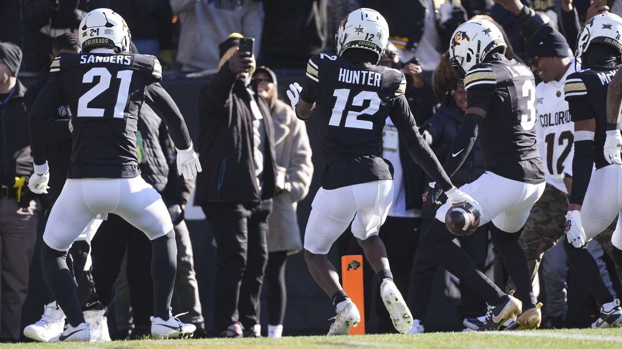 Colorado defensive back Travis Hunter, center, dances after intercepting a pass with safety Shilo Sanders, left, and cornerback Colton Hood in the first half of an NCAA college football game against Oklahoma State Friday, Nov. 29, 2024, in Boulder, Colo.