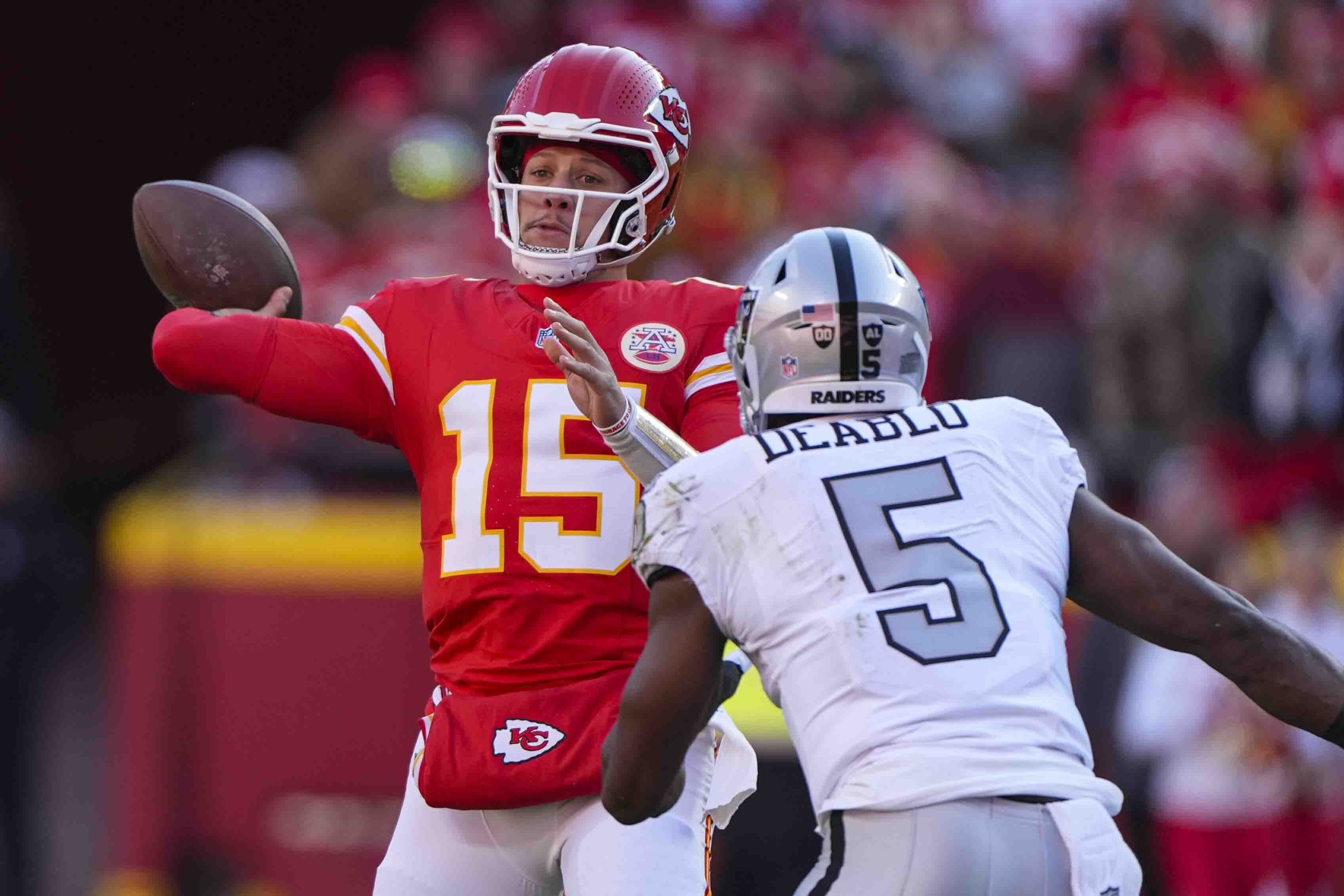 Kansas City Chiefs quarterback Patrick Mahomes (15) throws over Las Vegas Raiders linebacker Divine Deablo (5)\ during the first half of an NFL football game in Kansas City, Mo., Friday, Nov. 29, 2024.