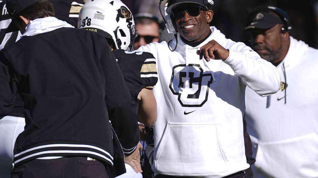 Colorado head coach Deion Sanders, right, congratulates place kicker Cristiano Palazzo after he kicked an extra point in the second half of an NCAA college football game against Oklahoma State, Friday, Nov. 29, 2024, in Boulder, Colo.