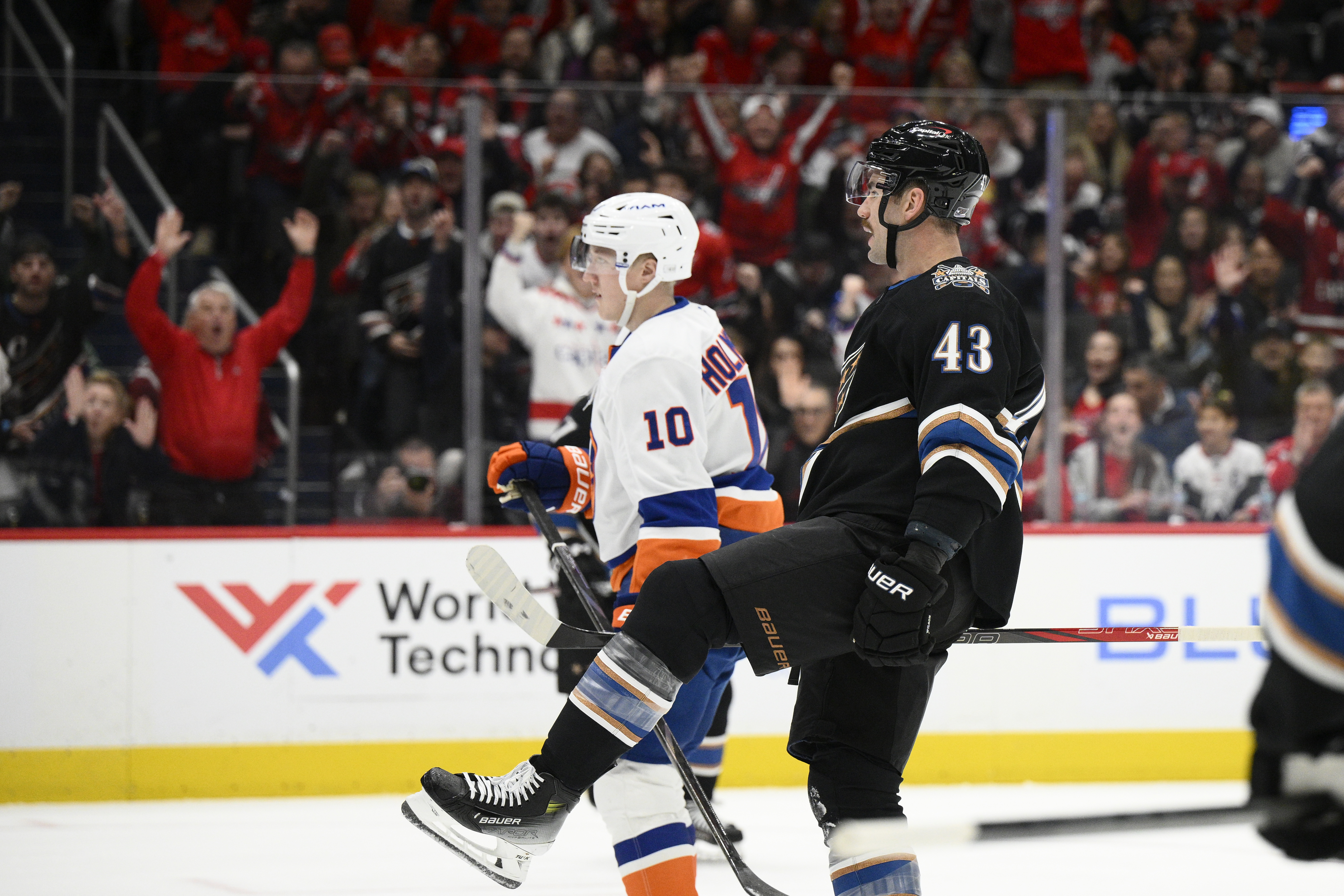 Washington Capitals right wing Tom Wilson (43) celebrates his goal next to New York Islanders right wing Simon Holmstrom (10) during the first period of an NHL hockey game, Friday, Nov. 29, 2024, in Washington. 