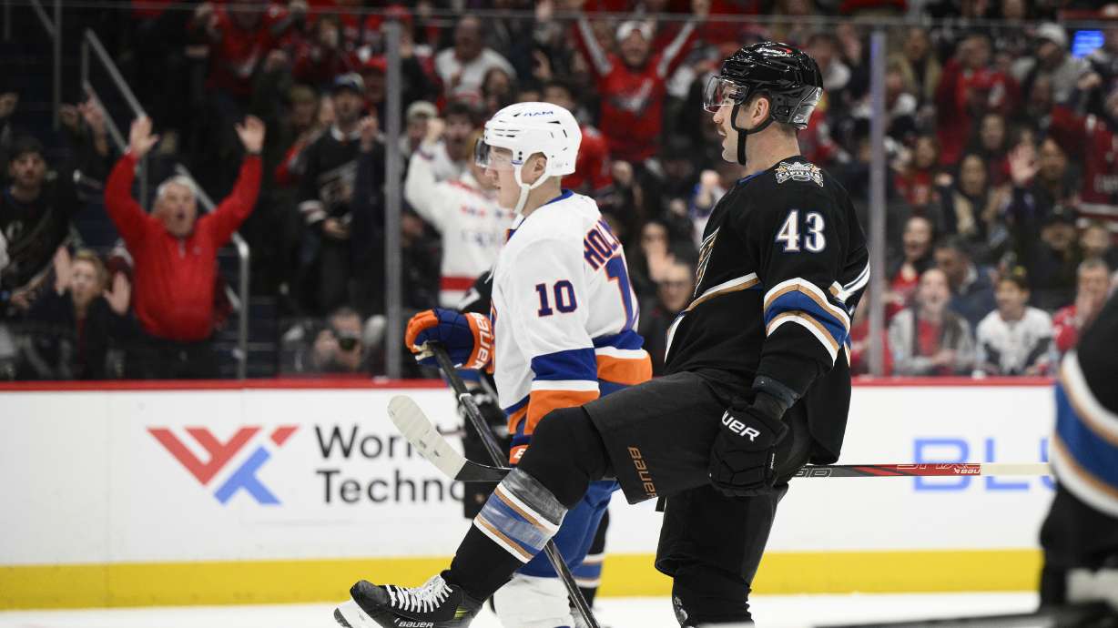 Washington Capitals right wing Tom Wilson (43) celebrates his goal next to New York Islanders right wing Simon Holmstrom (10) during the first period of an NHL hockey game, Friday, Nov. 29, 2024, in Washington.