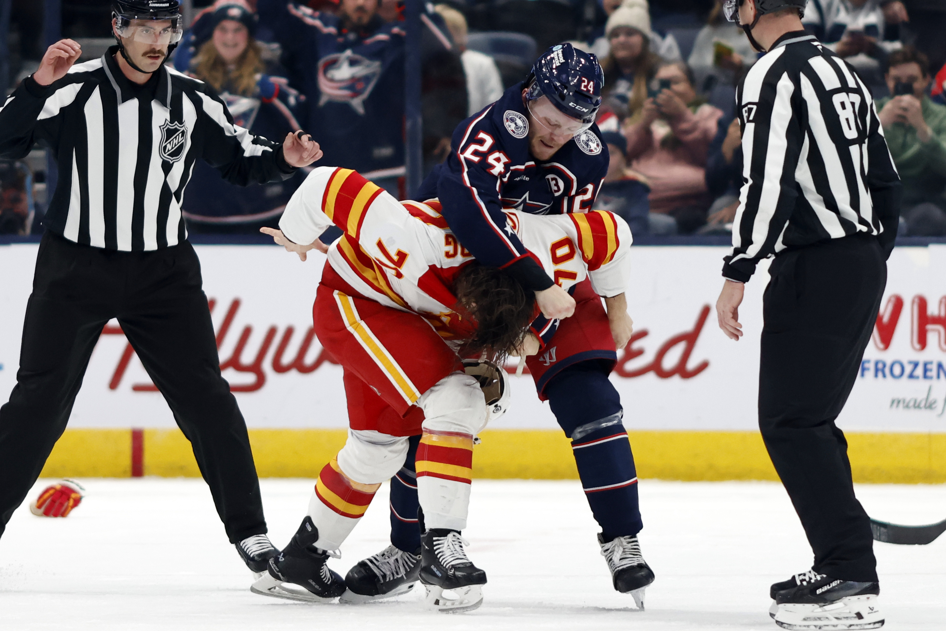 Columbus Blue Jackets forward Mathieu Olivier (24) fights with Calgary Flames forward Ryan Lomberg (70) during the second period of an NHL hockey game in Columbus, Ohio, Friday, Nov. 29, 2024. 