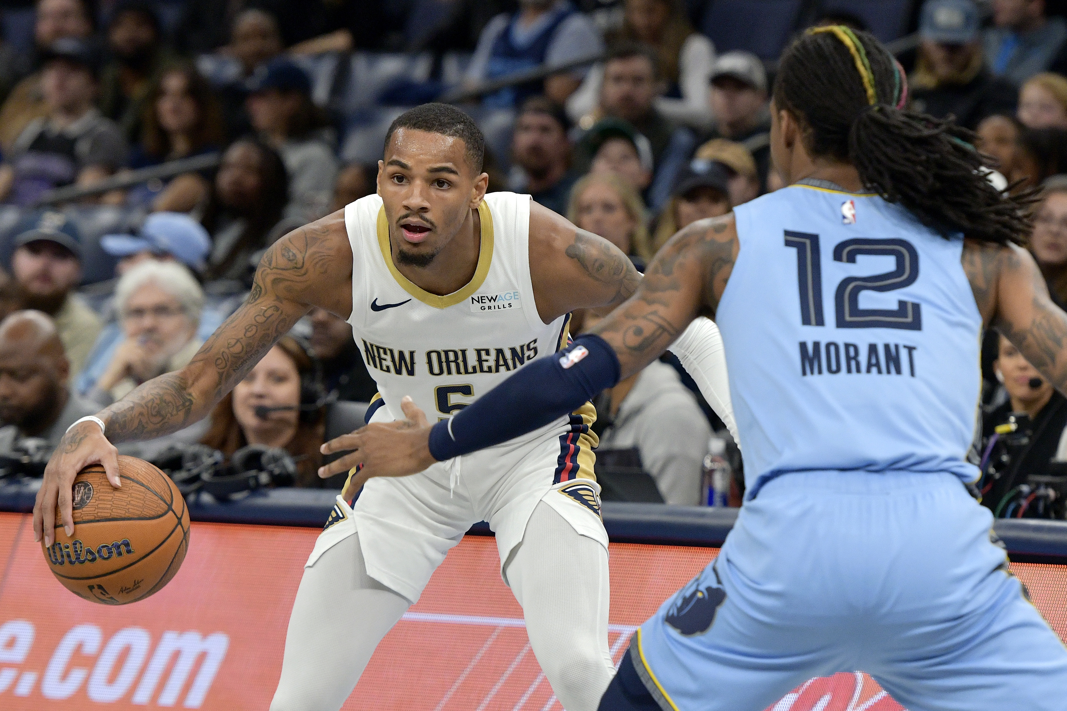 New Orleans Pelicans guard Dejounte Murray (5) handles the ball against Memphis Grizzlies guard Ja Morant (12) in the first half of an Emirates NBA Cup basketball game Friday, Nov. 29, 2024, in Memphis, Tenn. 
