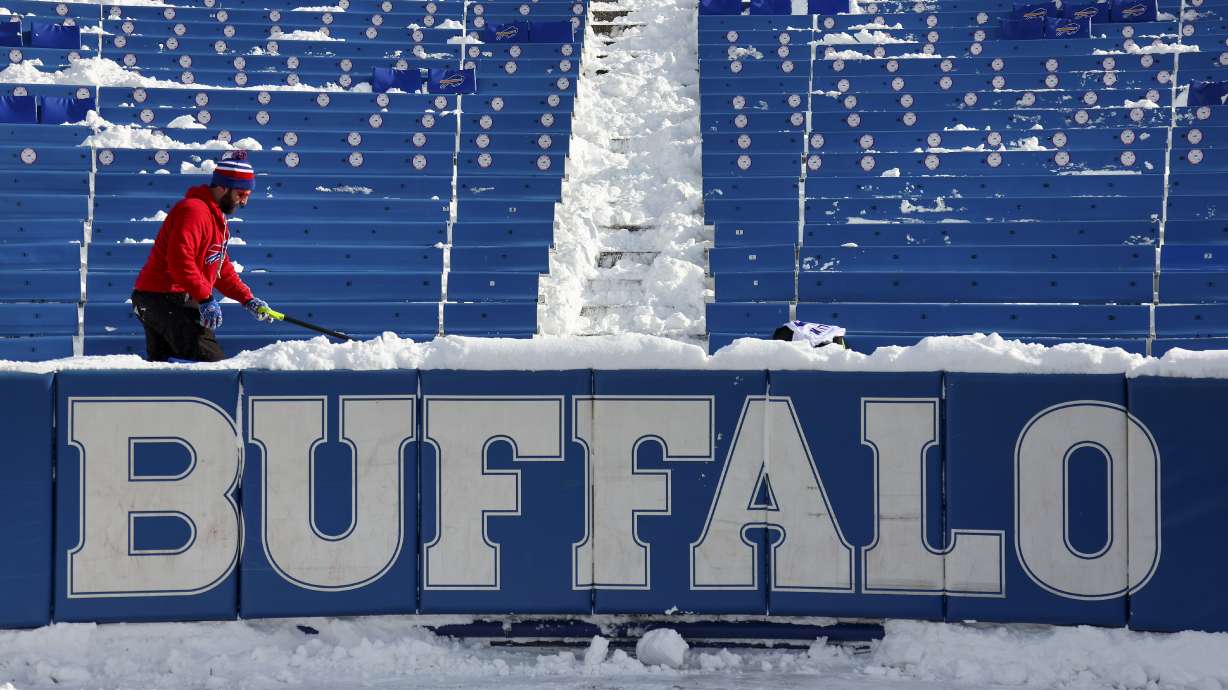 FILE - A stadium worker clears snow from seats before an NFL wild-card playoff football game between the Buffalo Bills and the Pittsburgh Steelers, Monday, Jan. 15, 2024, in Buffalo, N.Y.