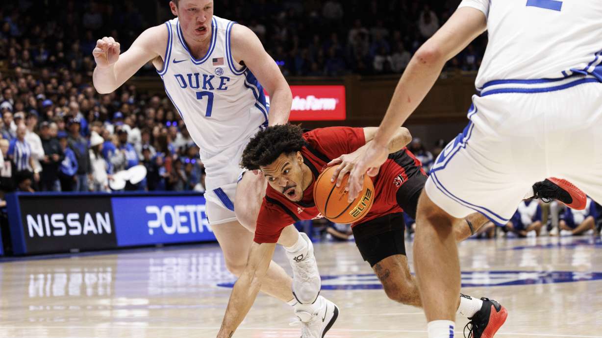 Seattle's Paris Dawson, center, falls while handling the ball as Duke's Kon Knueppel (7) defends during the first half of an NCAA college basketball game in Durham, N.C., Friday, Nov. 29, 2024.