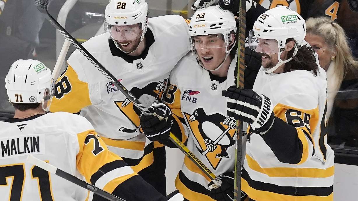 Pittsburgh Penguins' Philip Tomasino (53) celebrates his goal with Evgeni Malkin (71), Erik Karlsson (65) and Marcus Pettersson (28) during the third period of an NHL hockey game against the Boston Bruins, Friday, Nov. 29, 2024, in Boston.