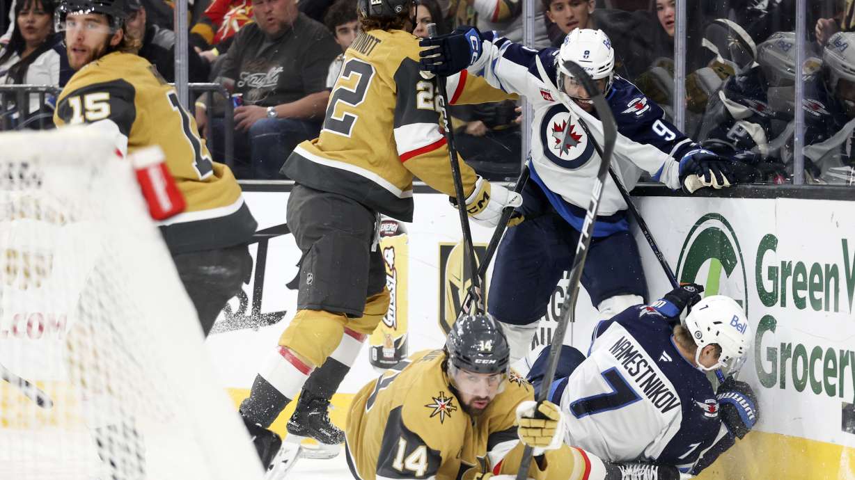 Vegas Golden Knights right wing Cole Schwindt (22) and defenseman Nicolas Hague (14) collide with Winnipeg Jets left wing Alex Iafallo (9) and center Vladislav Namestnikov (7) during the first period of an NHL hockey game Friday, Nov. 29, 2024, in Las Vegas.