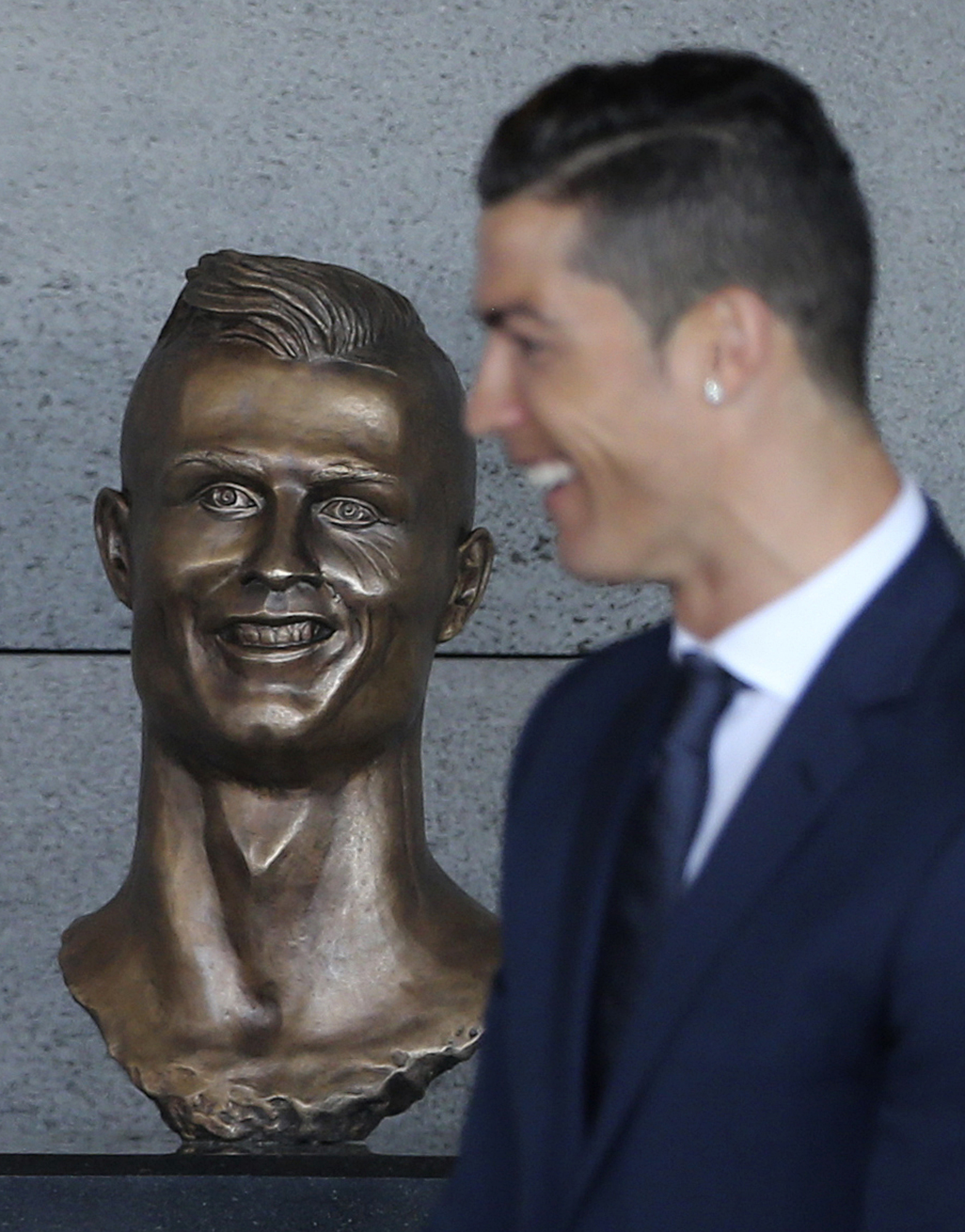 FILE - Real Madrid's Cristiano Ronaldo stands next to a bust of himself at the Madeira international airport outside Funchal, the capital of Madeira island, Portugal, Wednesday March 29, 2017. 