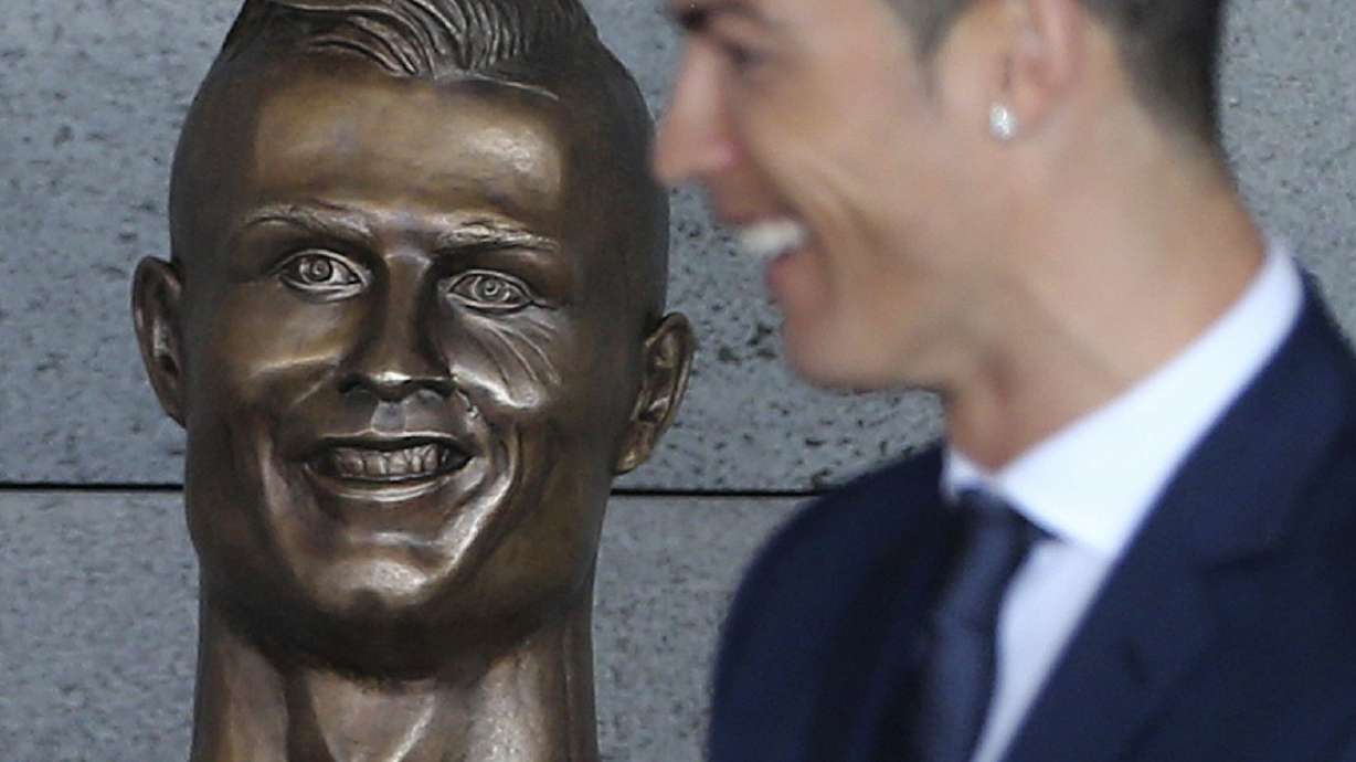 FILE - Real Madrid's Cristiano Ronaldo stands next to a bust of himself at the Madeira international airport outside Funchal, the capital of Madeira island, Portugal, Wednesday March 29, 2017.